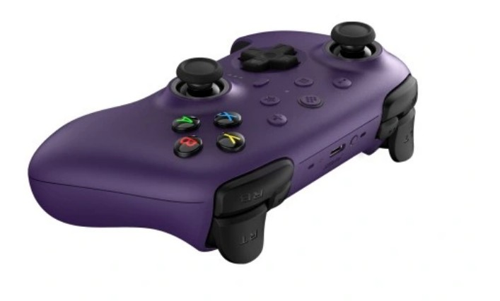 Fioletowy kontroler do gier z czarnymi joystickami, przyciskami i spustami. Na białym tle.