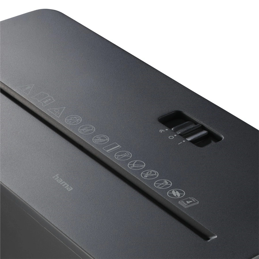 Zbliżenie czarnej niszczarki do papieru. Ma przełącznik z symbolami i ikonami ostrzegawczymi z boku. Widoczna jest marka 'hama'.