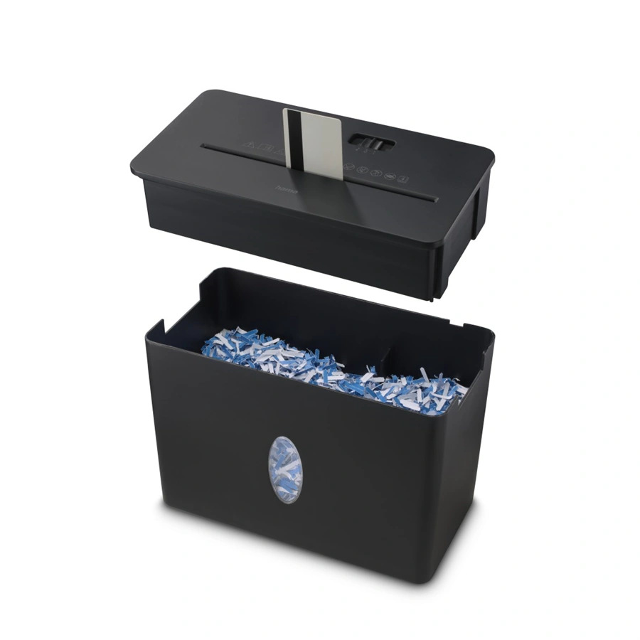 Czarna niszczarka do papieru z odłączoną górną częścią. Włożona jest karta kredytowa. Dolna część zawiera pocięty papier.
