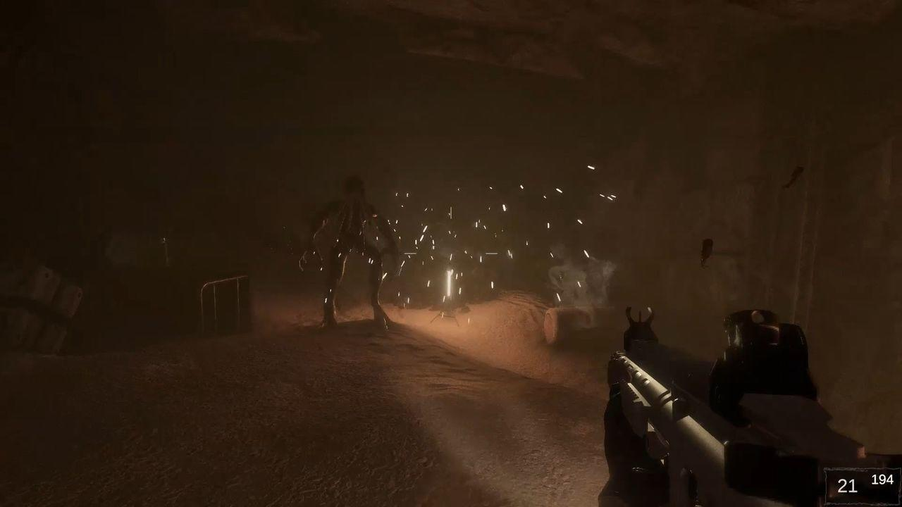 Eine Gestalt in einer schwach beleuchteten Höhle. Funken fliegen von einem zentralen Punkt. Eine Waffe wird im Vordergrund gehalten.