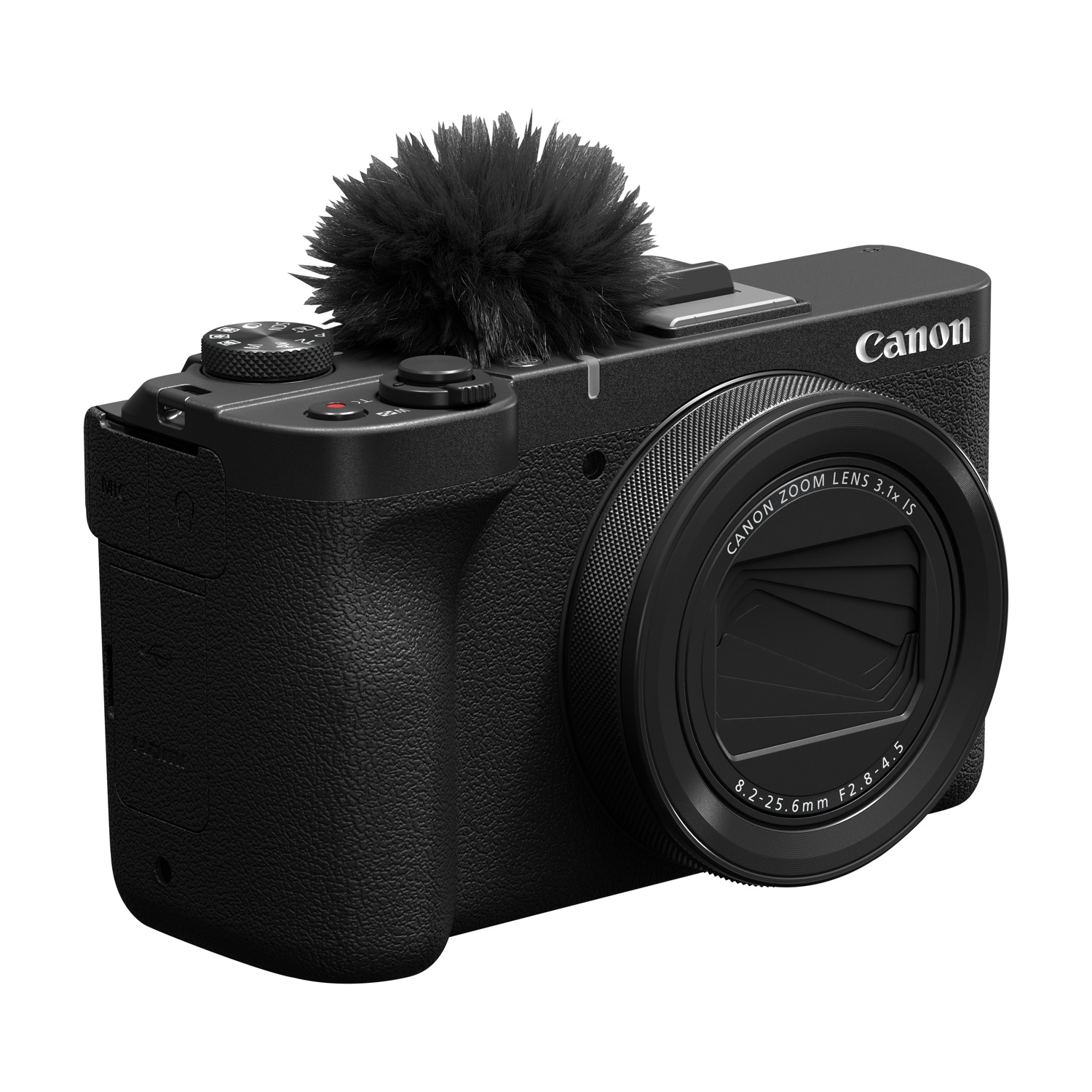Fotocamera Canon nera con microfono collegato. L'obiettivo riporta Canon Zoom Lens. La fotocamera è su una superficie bianca.