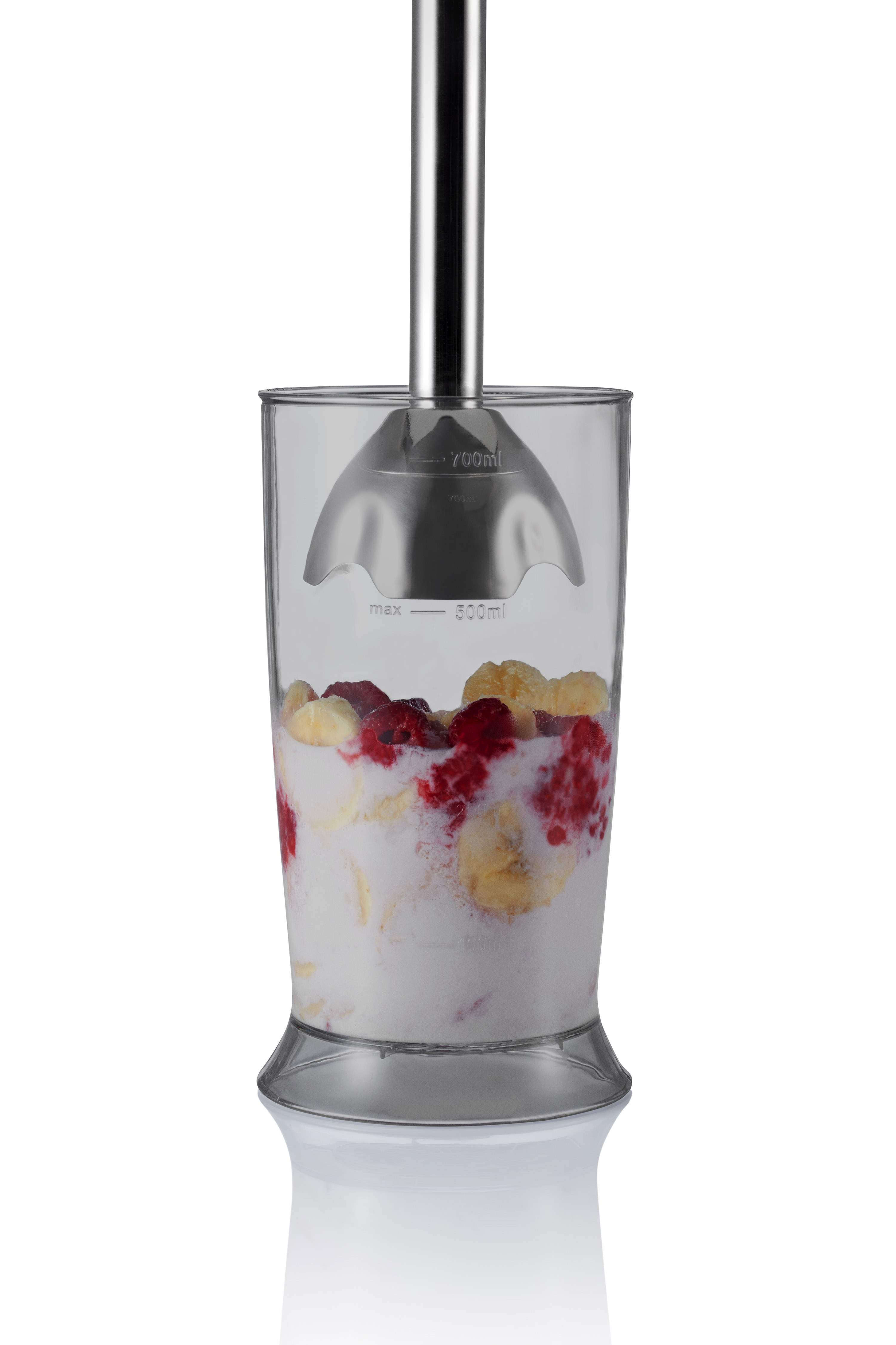 Meyve ve yoğurt dolu bir bardakla blender. Bardağa paslanmaz çelik bir blender yerleştirilir.