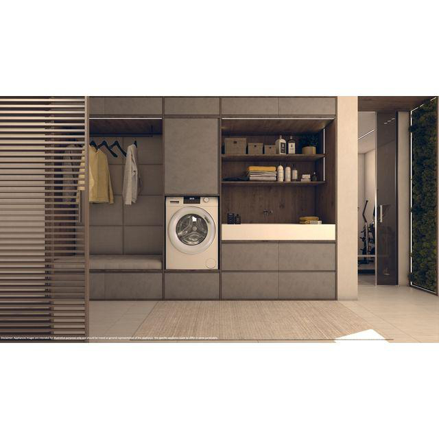 Ein Waschraum mit Waschmaschine, Stauraum und Einblick in ein Fitnessstudio. Links hängen Kleider. Regale mit Toilettenartikeln und Boxen.