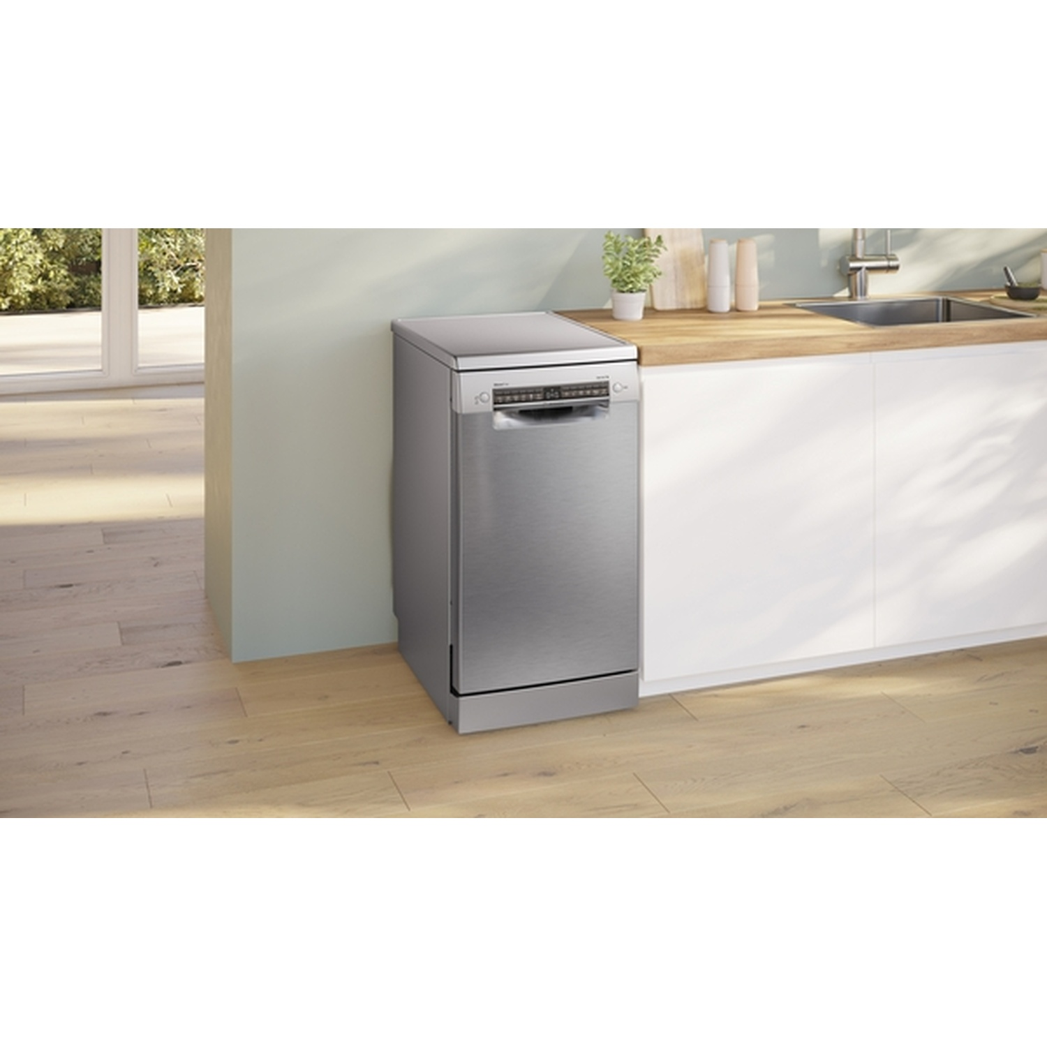 A stainless steel dishwasher stands next to a white cabinet and wooden counter. The floor is light wood.