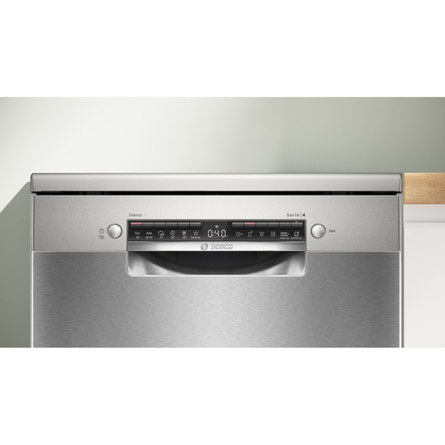 A stainless steel Bosch dishwasher. It has a digital display, various buttons, and a handle. The background is a light wall and wood.