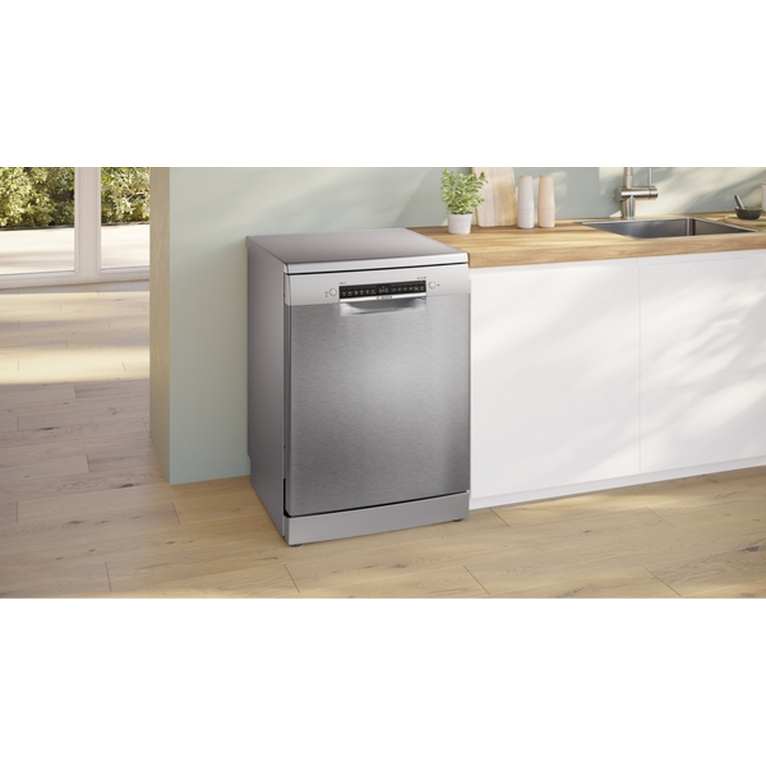 A stainless steel dishwasher stands near a light-colored wall and wooden countertop. The floor is wooden.