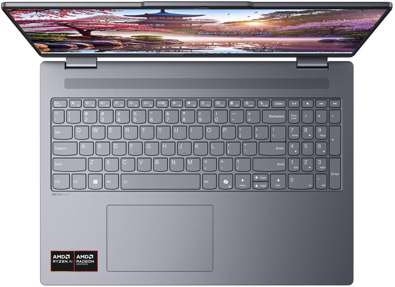 Nyitott képernyős laptop, tájképpel. Látható billentyűzet AMD Ryzen AI és Radeon Graphics logókkal.