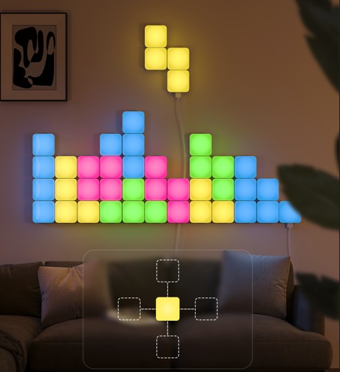 Duvara Tetris benzeri bir desende dizilmiş renkli, aydınlatmalı kareler. Altta bir kanepe ve çerçeveli bir sanat eseri.