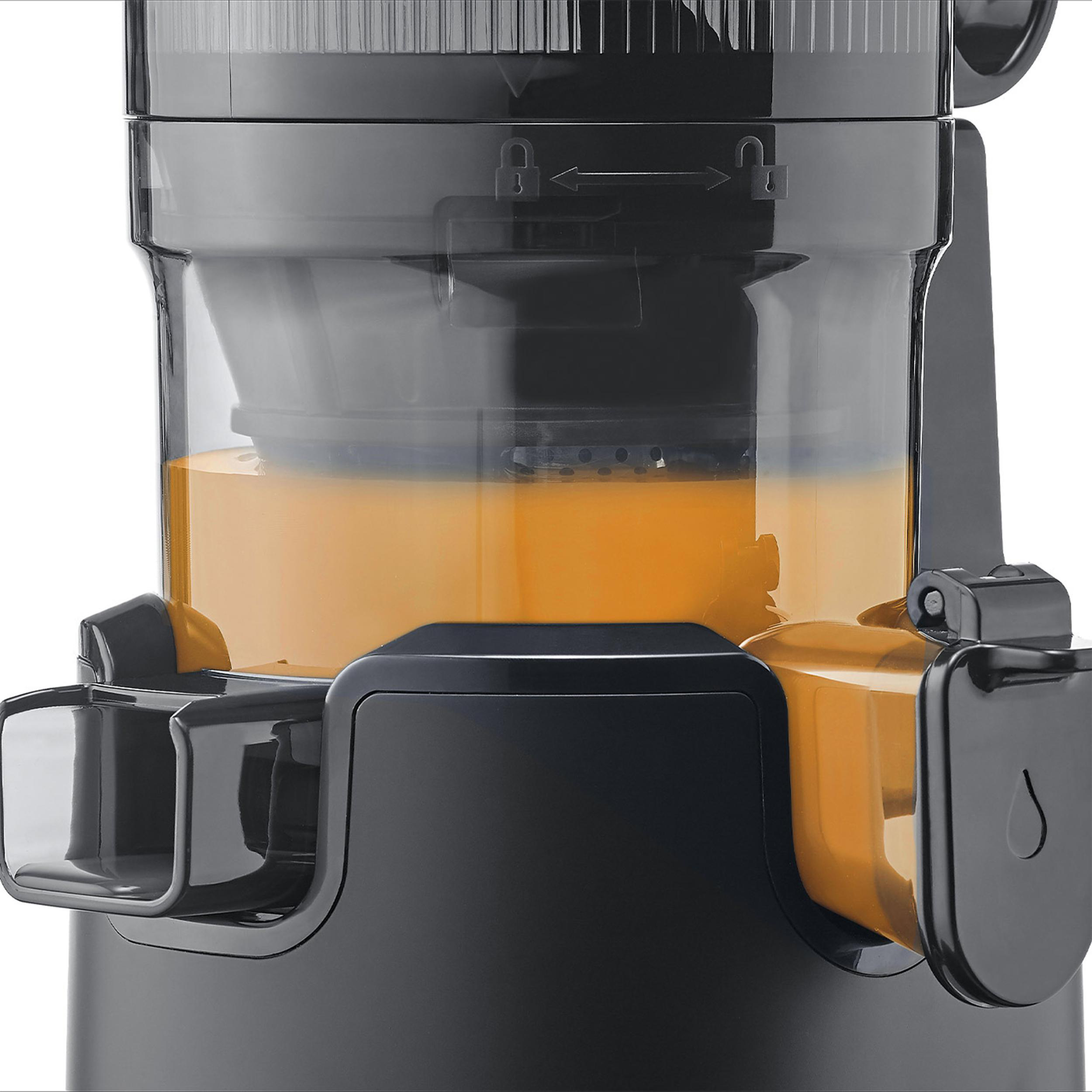 Nahaufnahme eines Entsafters. Er hat schwarze und orangefarbene Teile und einen transparenten Behälter mit Orangensaft.