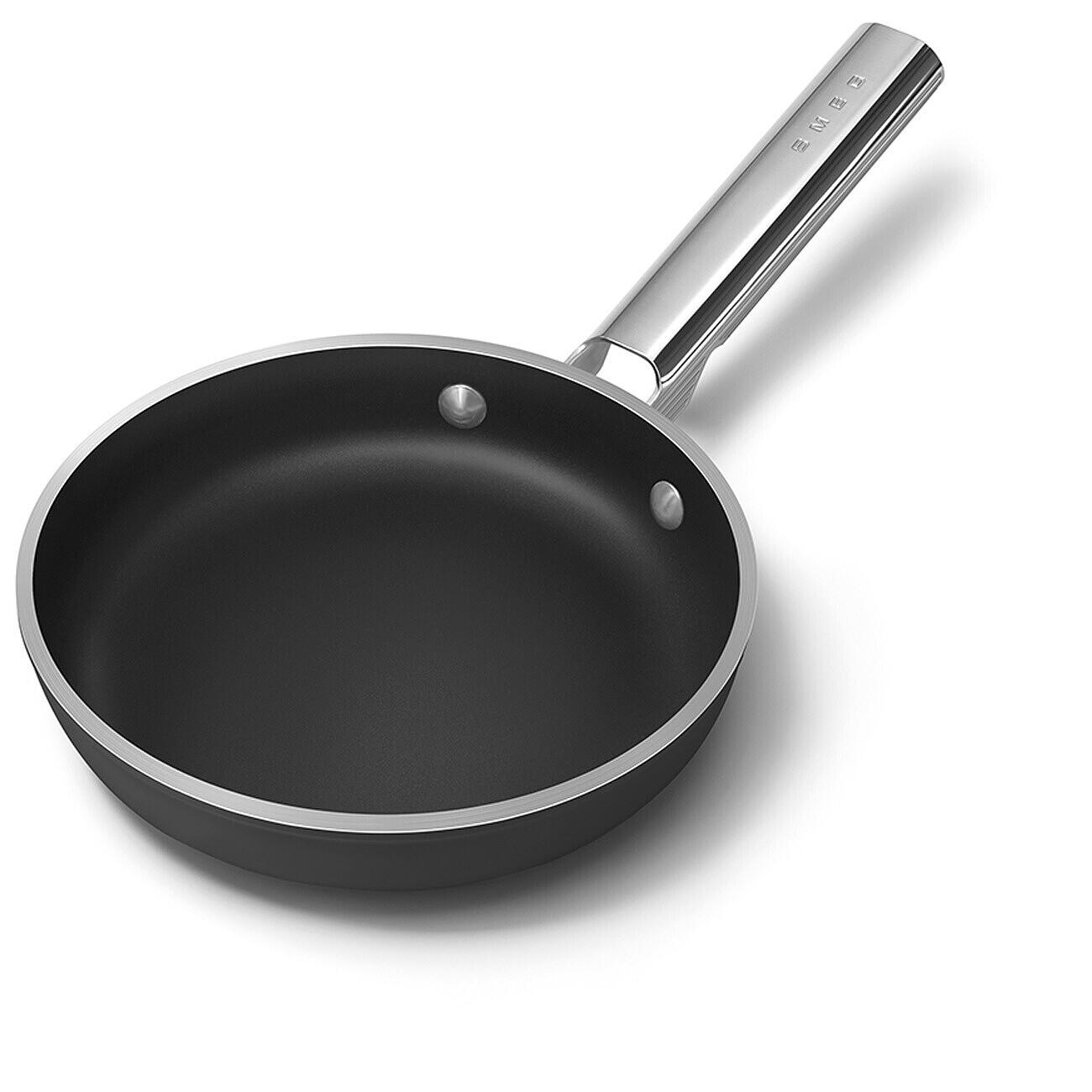 Eine schwarze Bratpfanne mit silbernem Griff auf weißem Hintergrund. Der Griff trägt das Wort 'smeg'.