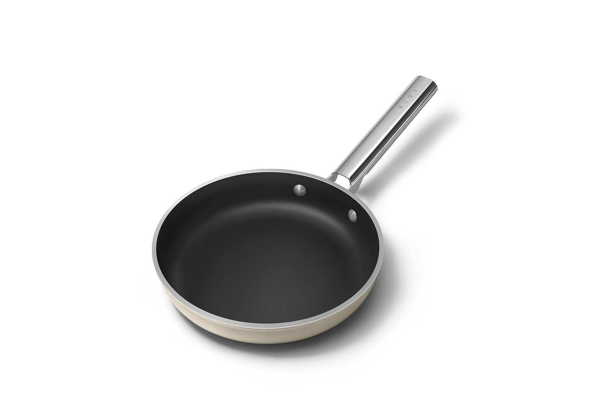 Eine Bratpfanne mit silbernem Griff und schwarzer Kochfläche liegt auf weißem Hintergrund.