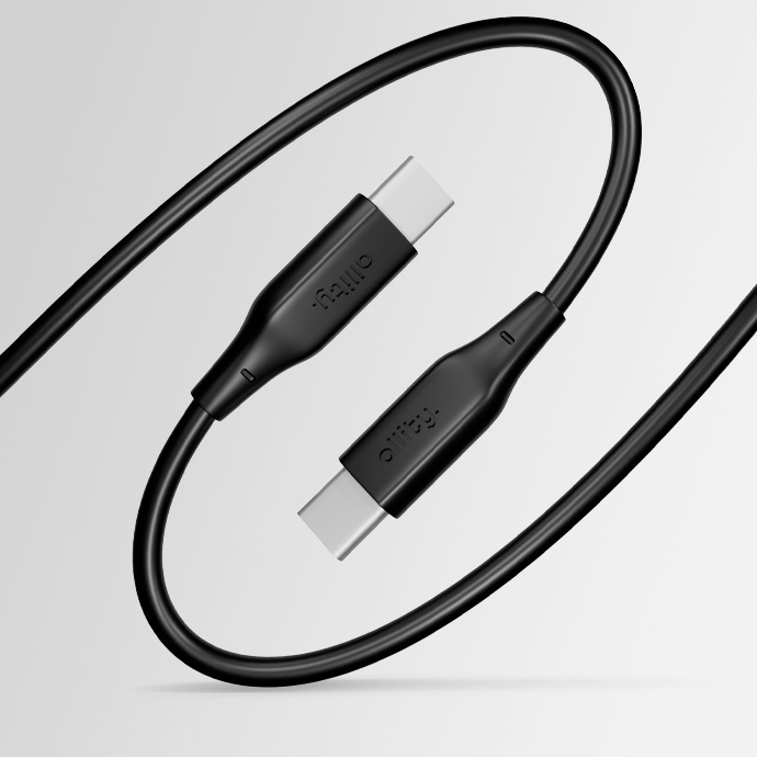 Egy fekete USB-C kábel, két csatlakozóval. A csatlakozók feketék, ezüst betétekkel. A kábel világosszürke háttér előtt van feltekerve.