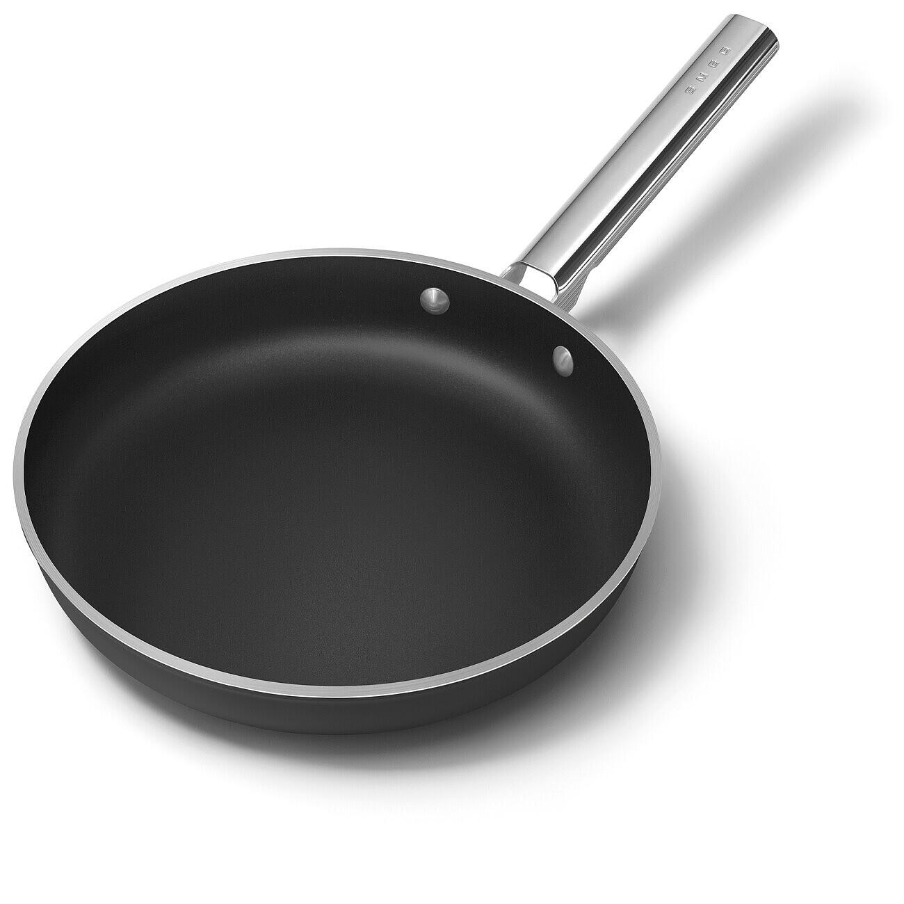 Eine schwarze Bratpfanne mit silbernem Griff auf weißem Hintergrund. Die Pfanne ist rund mit silbernem Rand. Der Griff hat das Wort SMEG.