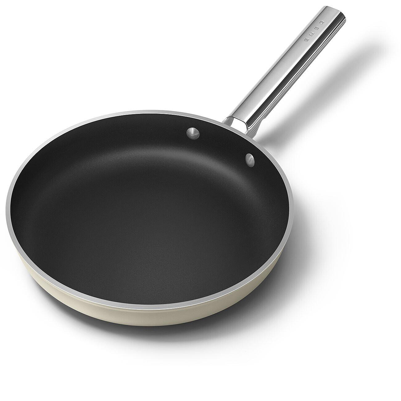 Eine beige-schwarze Bratpfanne mit silbernem Griff auf weißem Untergrund. Auf dem Griff steht SMEG.