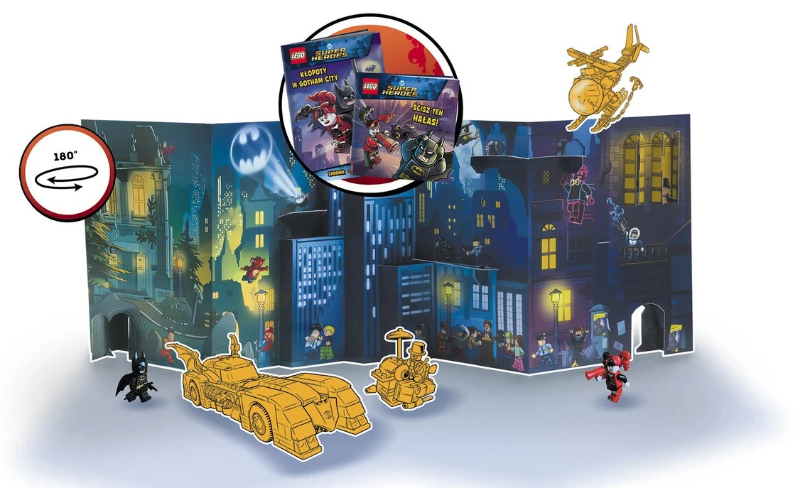 Scena pop-up Lego Batman z budynkami miejskimi, postaciami i Batmobilem. Obecni są Harley Quinn i Batman. Książki w tle.