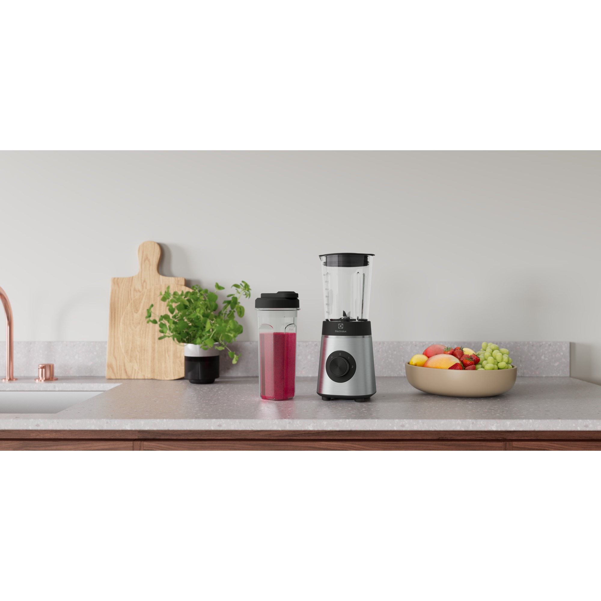 Mutfak tezgahı, blender, smoothie, meyve kasesi ve kesme tahtası. Beyaz duvar arka planı.