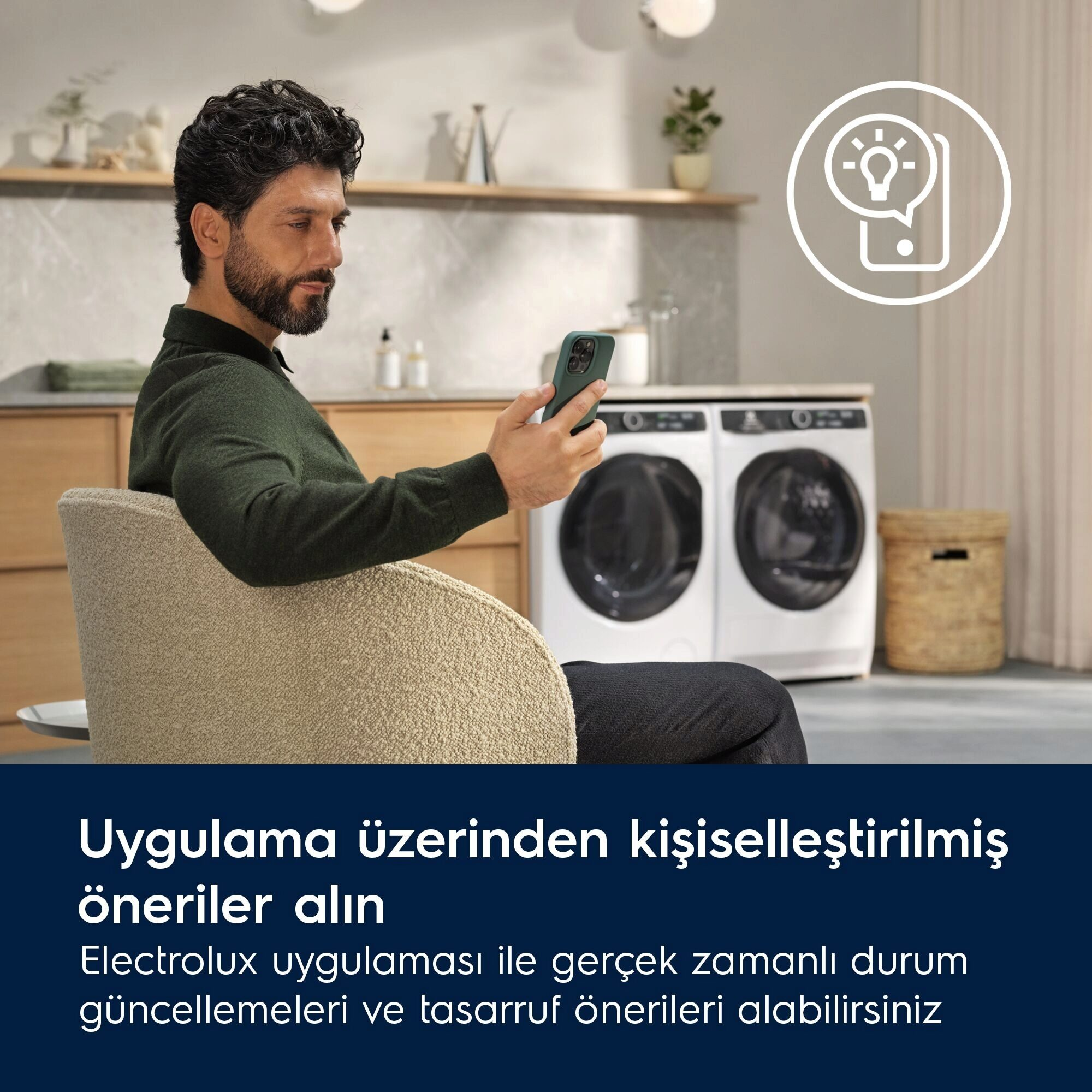 Adam telefon tutuyor, çamaşır makinelerinin yanında oturuyor. Üstte bir ampul simgesi var. Metin: Kişiselleştirilmiş öneriler.