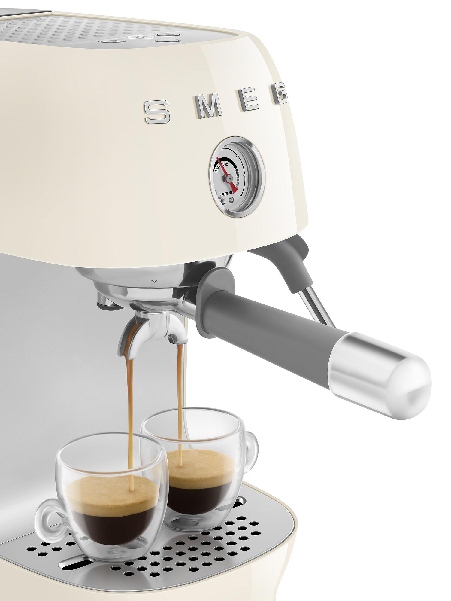Creme-Espressomaschine mit Kaffee, der in Gläser gegossen wird. Manometer und grauer Griff sind sichtbar.