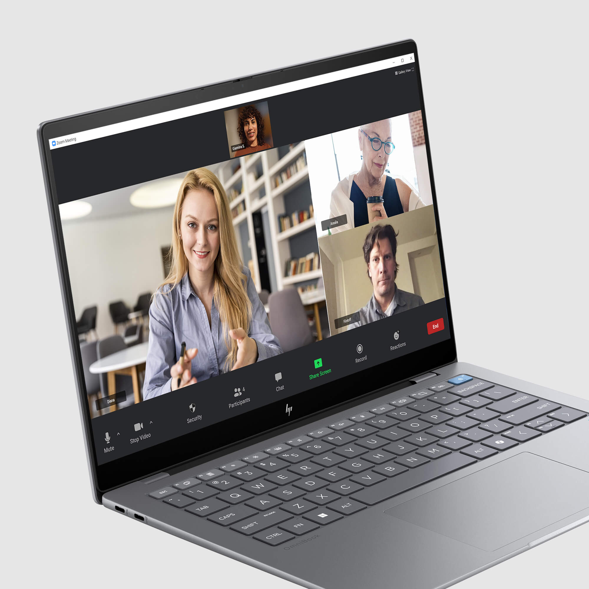 Ekran laptopa pokazuje spotkanie Zoom z czterema uczestnikami. Kobieta klaszcze, trzech innych jest na ekranie.