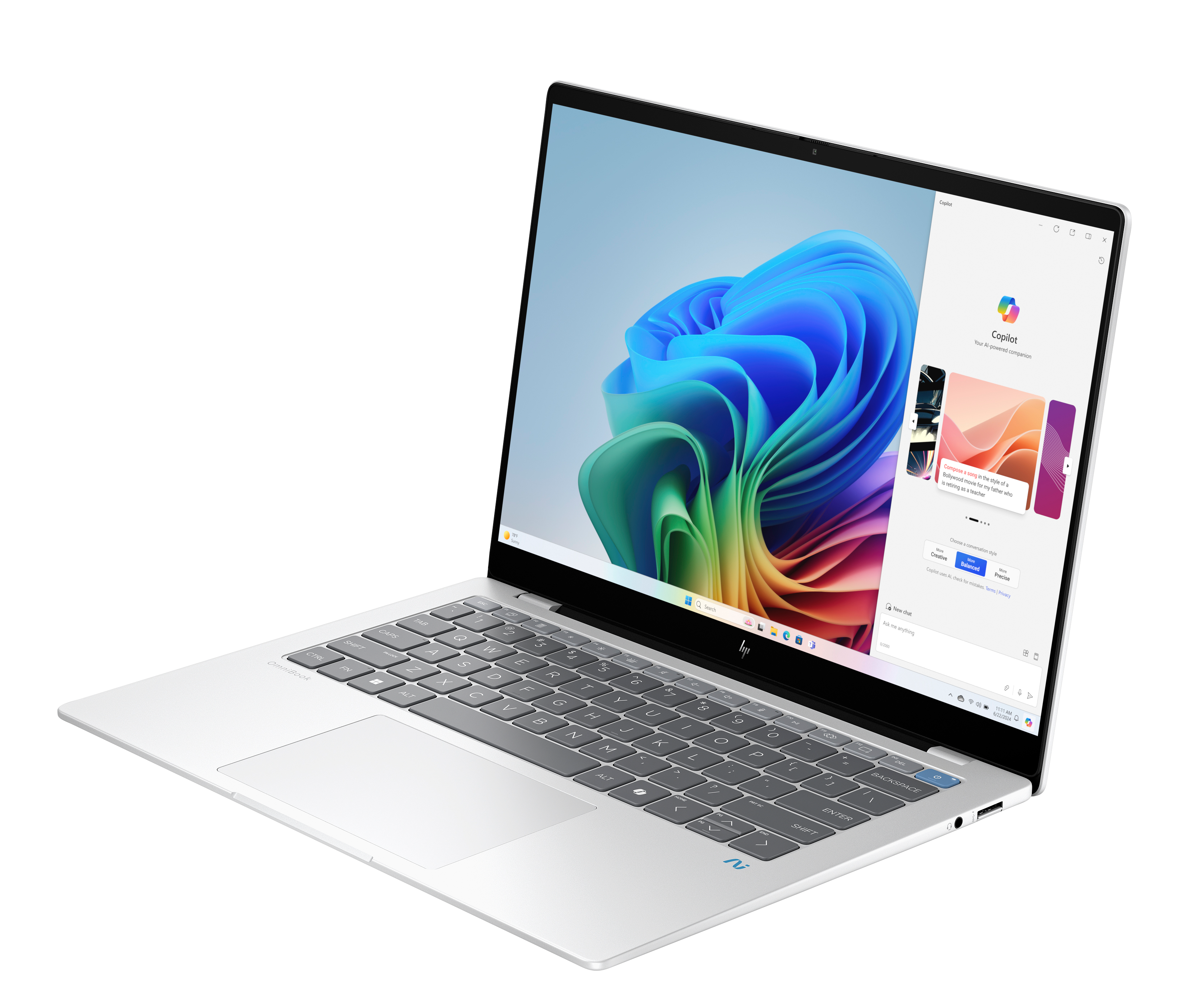 Srebrny laptop HP jest otwarty, wyświetlając kolorowy abstrakcyjny obraz. Okno Copilot jest otwarte.