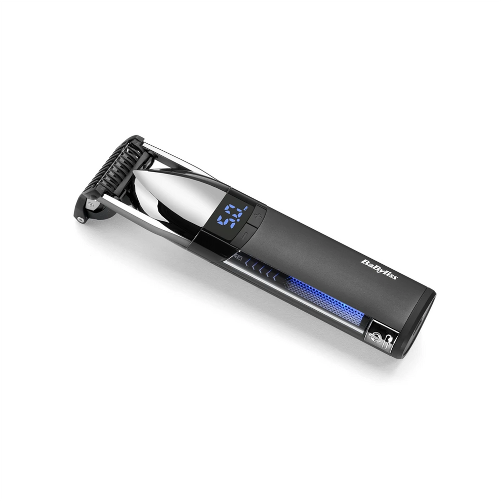 Egy fekete-ezüst BaByliss szakállvágó fehér háttéren. Digitális kijelzője van, és a márkanév látható.