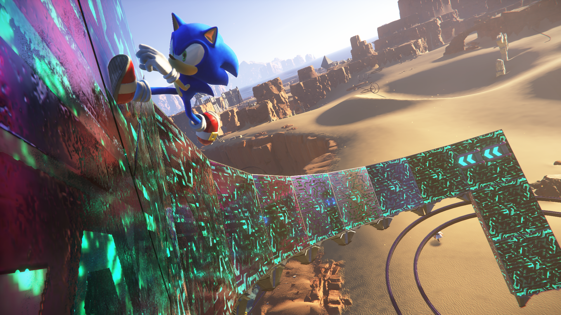 Sonic the Hedgehog parlayan bir duvara tırmanıyor, arka planda çöl manzarası. Ön planda fütüristik bir yol var.