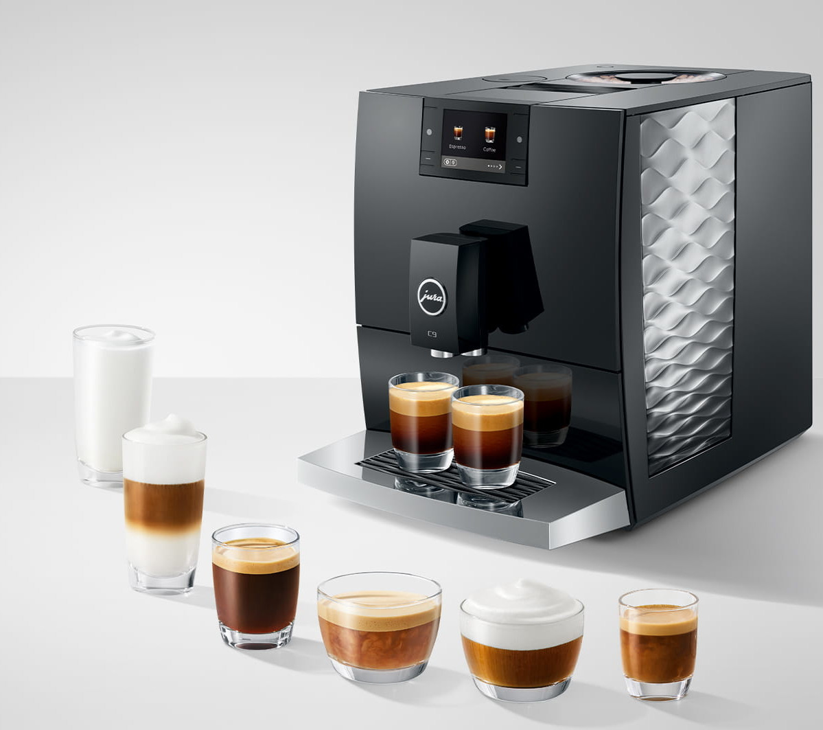 Czarny ekspres do kawy Jura z różnymi napojami kawowymi w szklankach. Napoje obejmują espresso, latte i cappuccino, wszystko na białej powierzchni.
