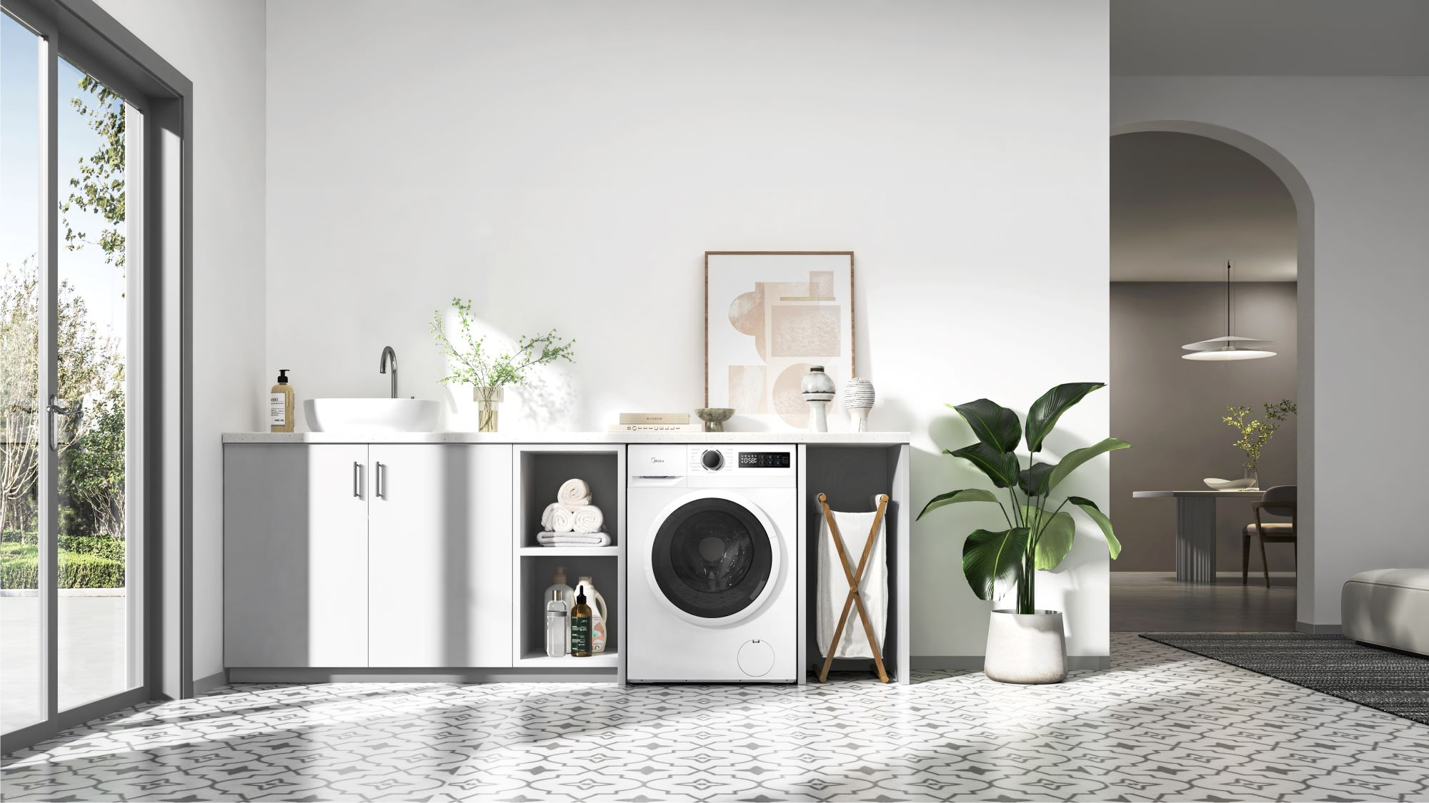 Cuarto de lavado con lavadora, lavabo y objetos decorativos. Se ve una ventana grande y un arco que conduce a otra habitación.