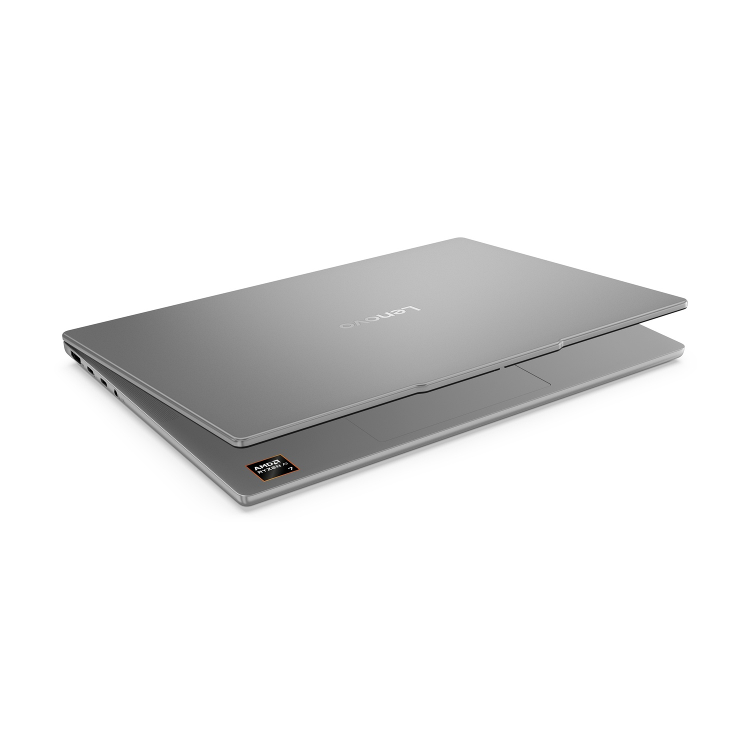 Un laptop Lenovo argentato, leggermente aperto, su sfondo bianco. Visibile adesivo AMD Ryzen 7.