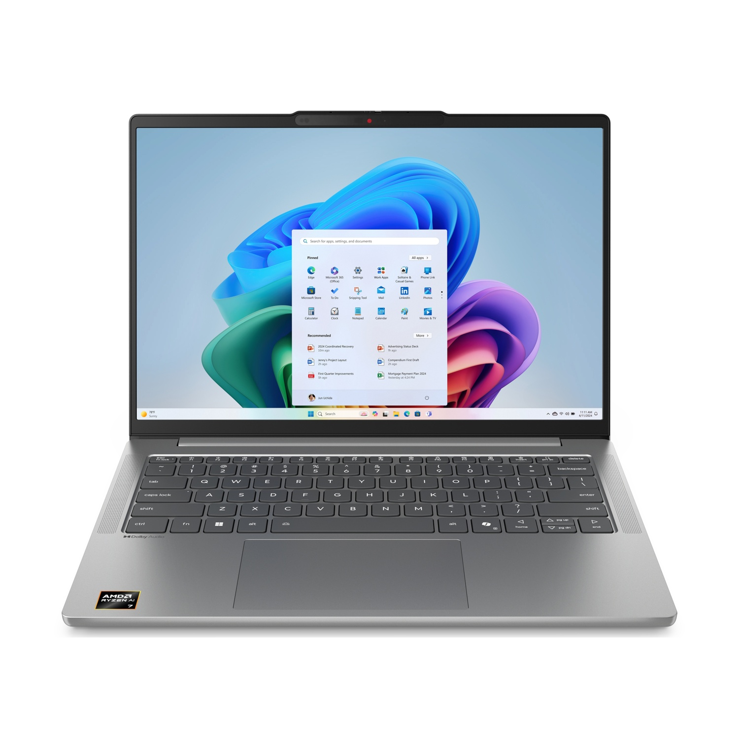 Laptop argento aperto, mostra interfaccia Windows 11. Tastiera visibile, con adesivo AMD Ryzen AI. Sfondo bianco.