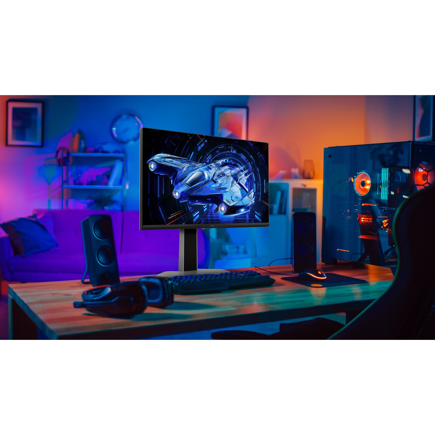 Configuration de jeu avec moniteur affichant un vaisseau spatial, des haut-parleurs, un clavier, une souris, une tour PC et un casque sur un bureau, avec éclairage violet et orange.