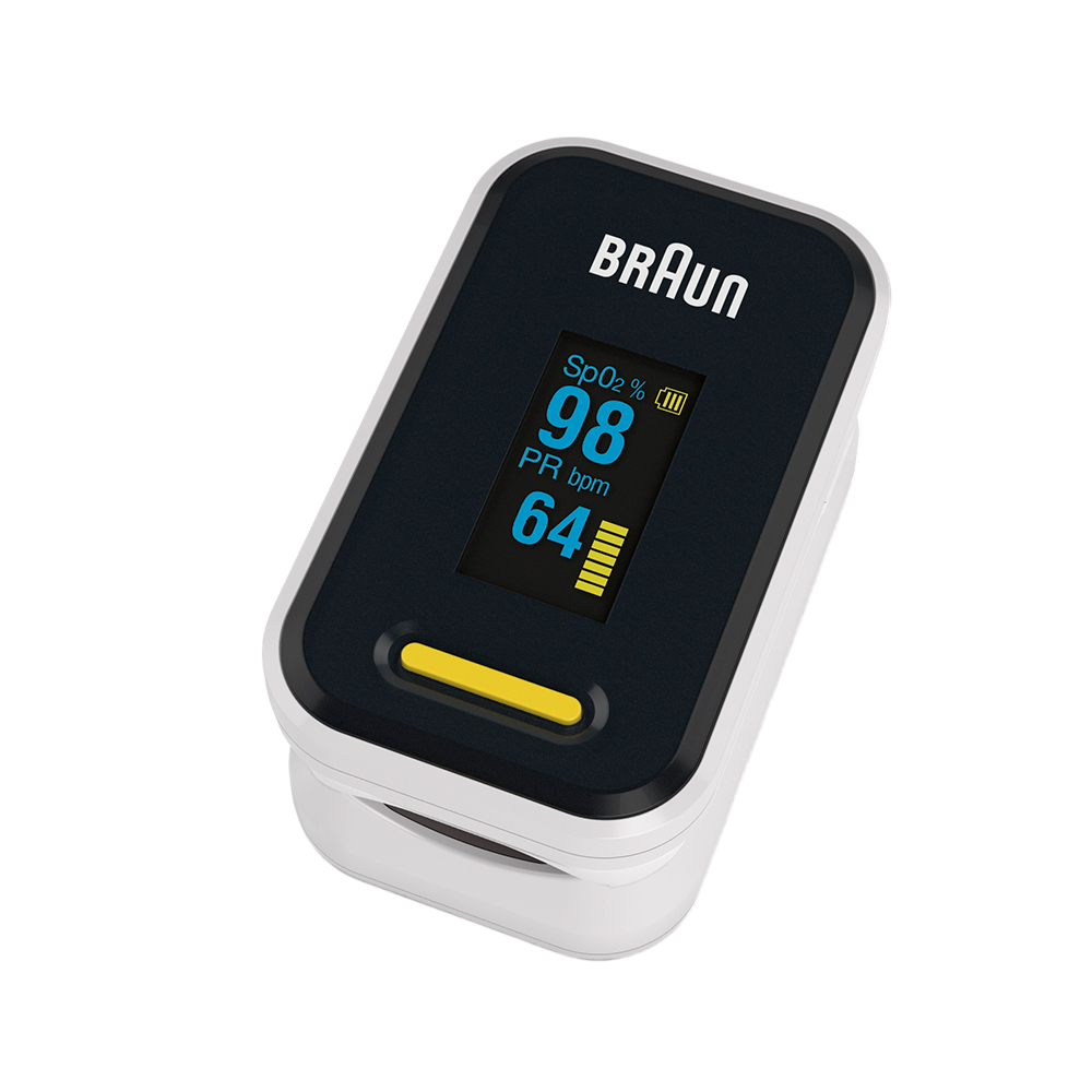 Ein Braun-Pulsoximeter zeigt SpO2 98 %, PR bpm 64 an. Es ist weiß und schwarz mit gelber Taste, vor schwarzem Hintergrund.