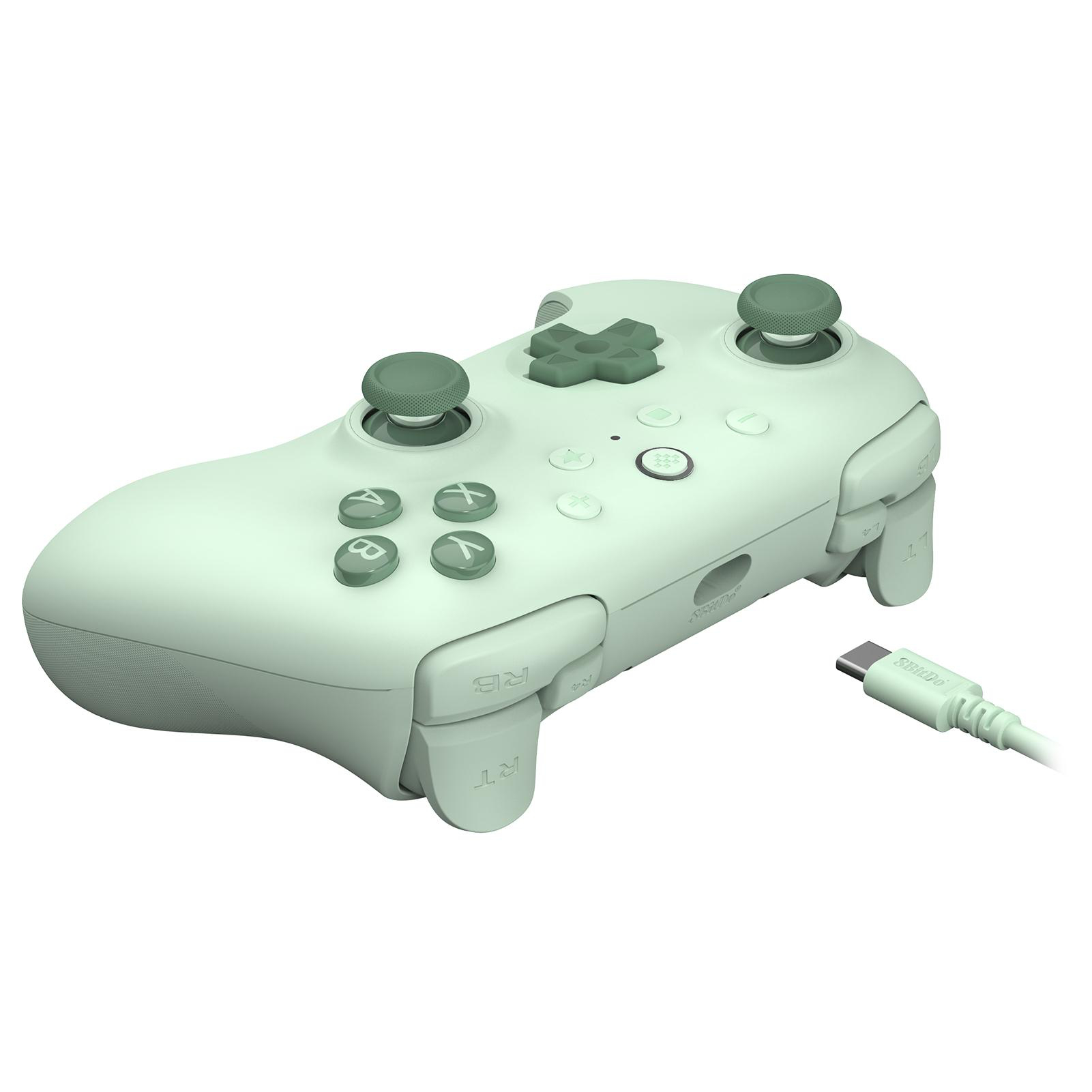 Ein hellgrüner Gamecontroller mit angeschlossenem Kabel. Knöpfe und Joysticks sind sichtbar. Der Hintergrund ist weiß.