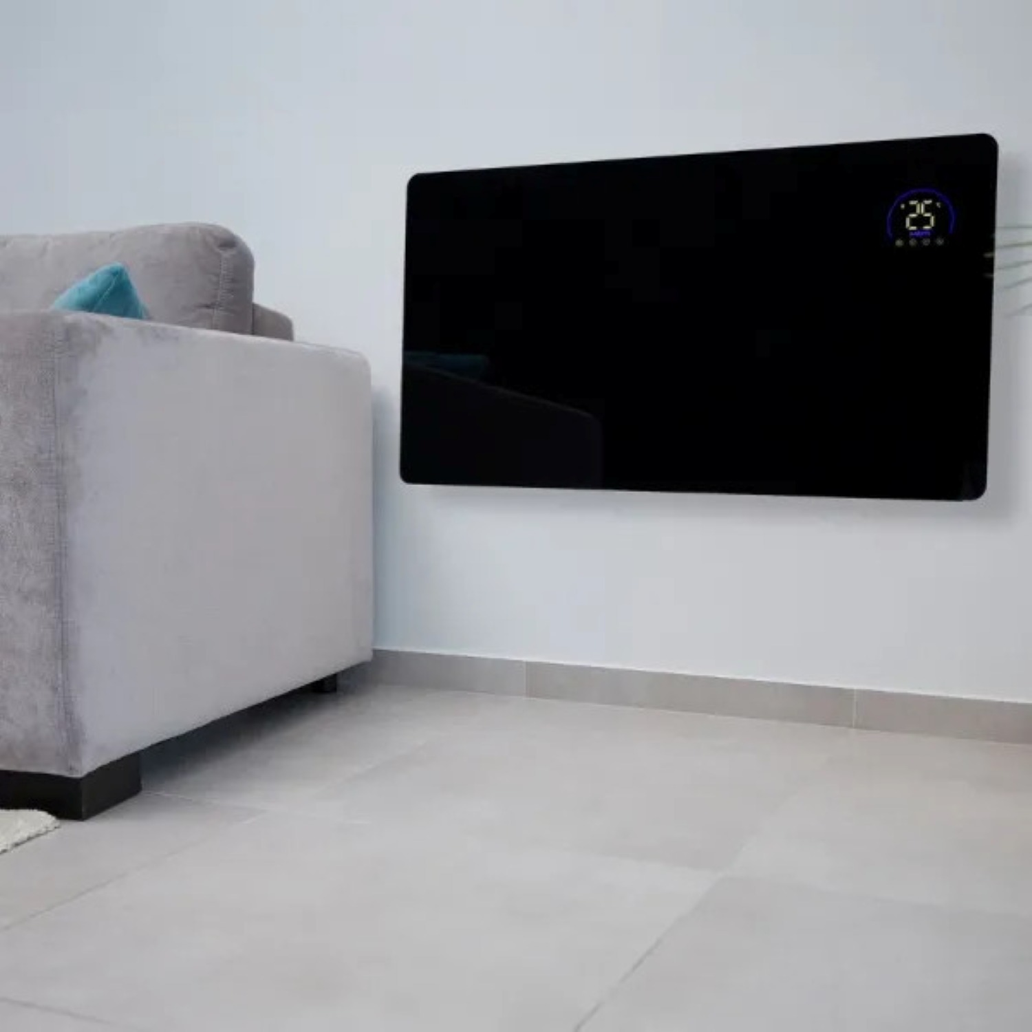 Czarny grzejnik panelowy na białej ścianie. Szara sofa po lewej. Grzejnik wyświetla '25'. Jasnoszara podłoga.