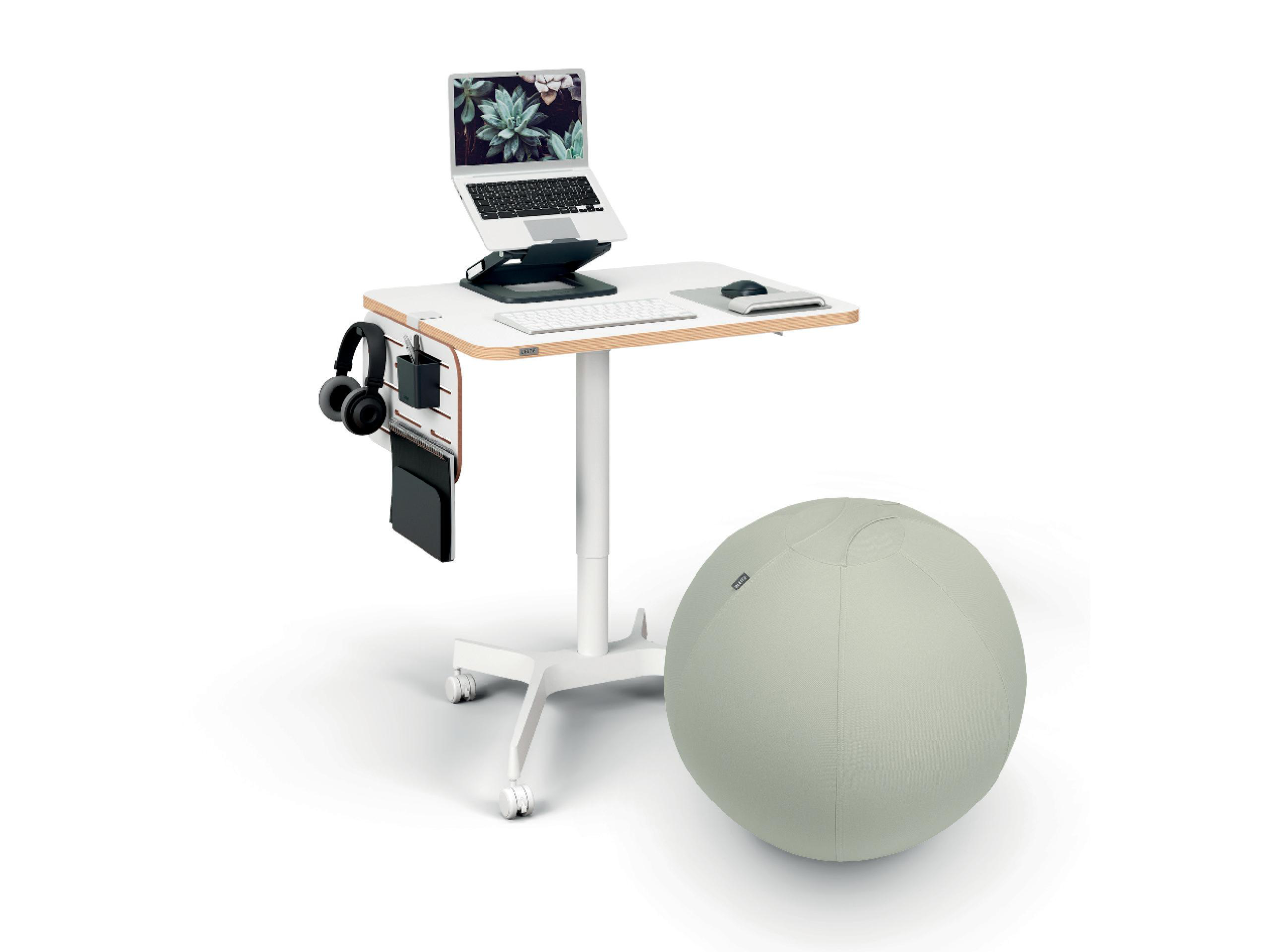Ein weißer Schreibtisch mit Laptop, Kopfhörern, Tastatur und hellgrünem Ball. Der Schreibtisch ist rollbar.