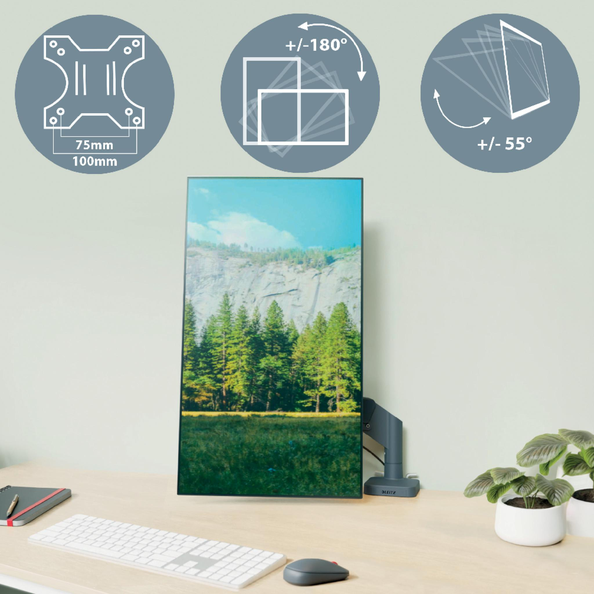 Monitor zeigt Landschaftsszene auf einem Schreibtisch mit Zubehör und Diagrammen. Graue Diagramme zeigen Bewegung und Abmessungen.