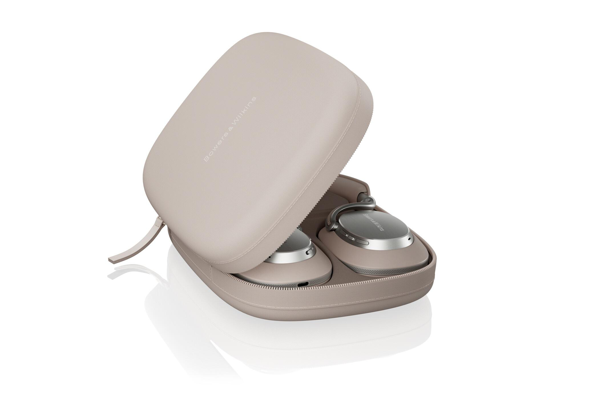 Beige Kopfhörer in einem geöffneten Etui. Etui und Kopfhörer sind beige und silber. Der Markenname ist auf dem Etui sichtbar.