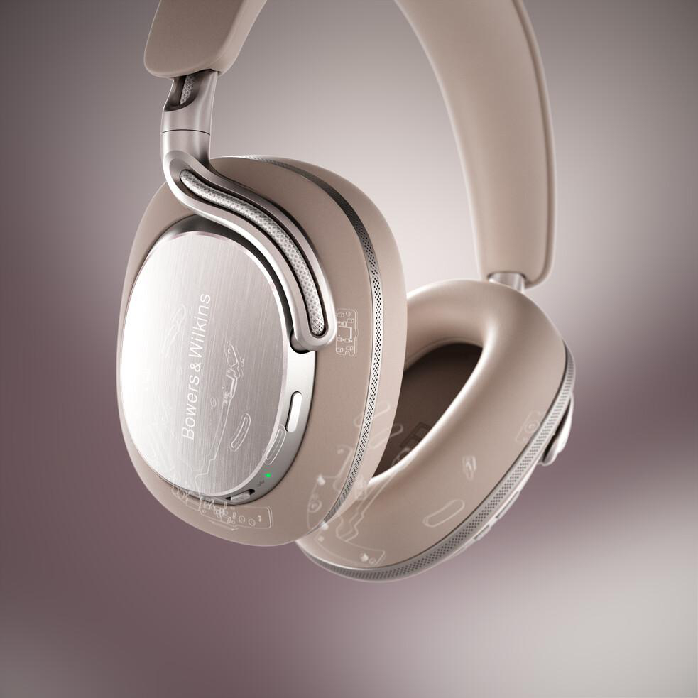 Beige Kopfhörer von Bowers & Wilkins mit silbernen Akzenten schweben vor einem farbverlaufenden Hintergrund.
