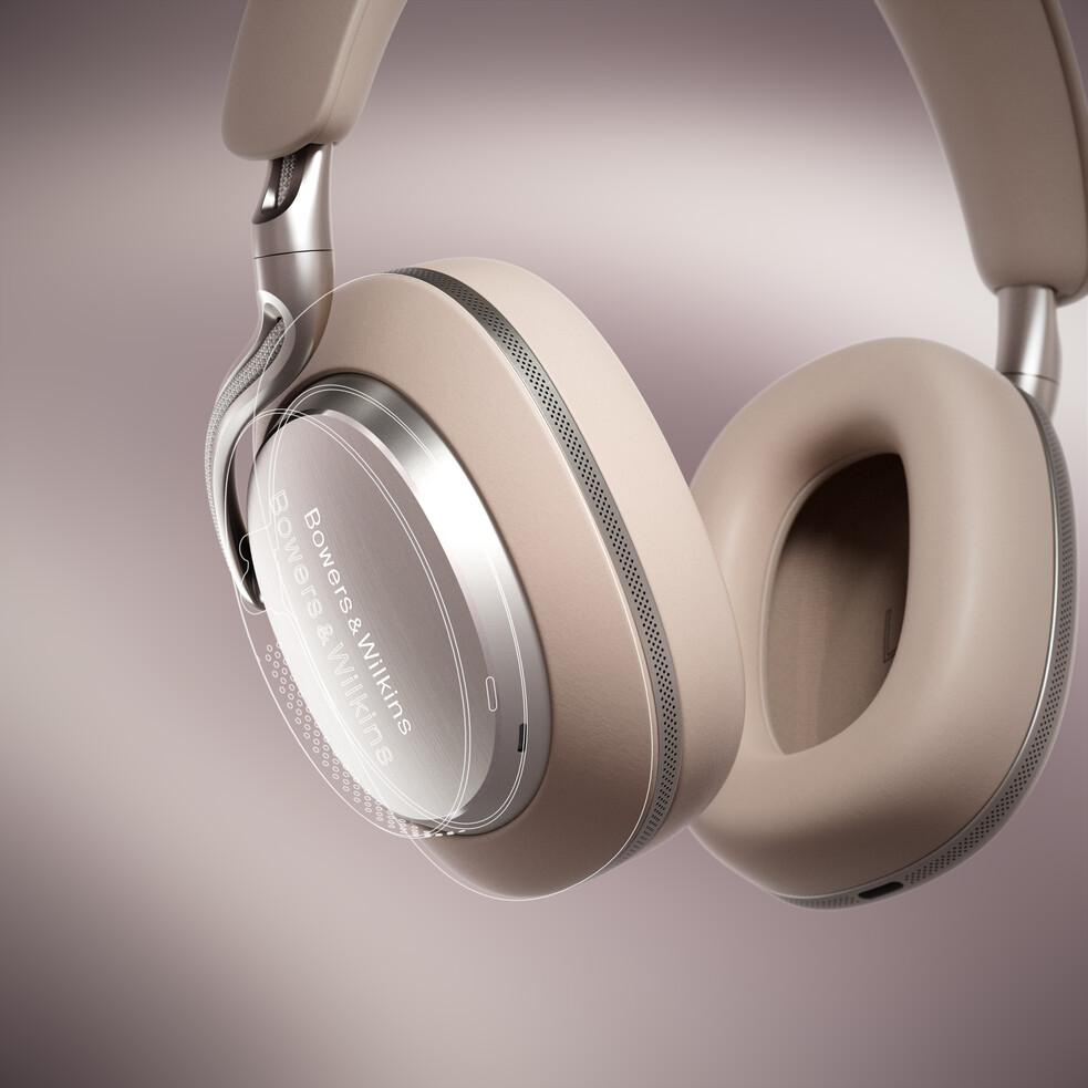 Beige Bowers & Wilkins Kopfhörer. Silberne Akzente. Die Ohrmuscheln sind groß und oval. Der Hintergrund ist ein Beige- und Lila-Farbverlauf.