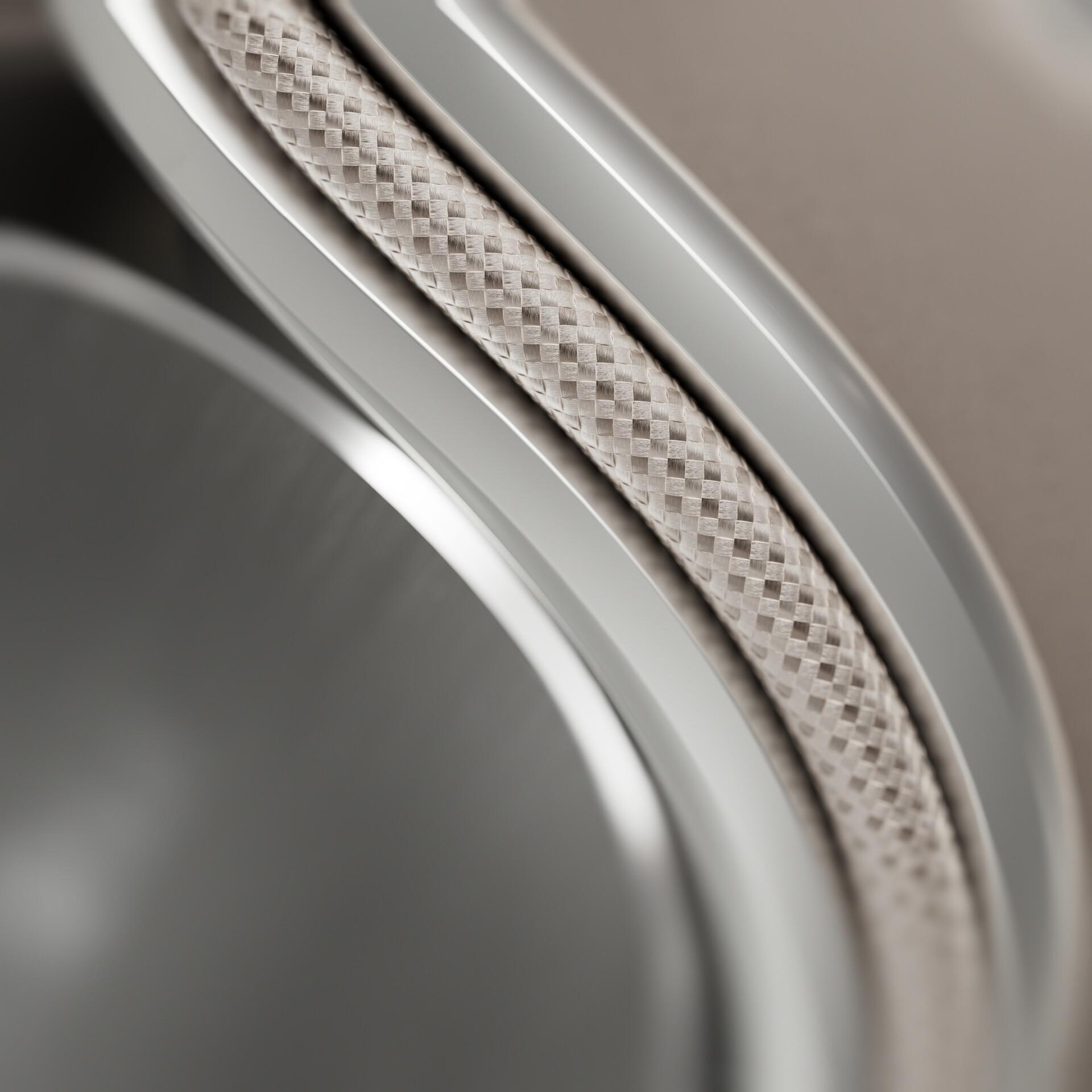 Nahaufnahme einer Uhrkomponente mit gewebtem Armband und gebogenem Metallrahmen. Der Hintergrund ist beige.