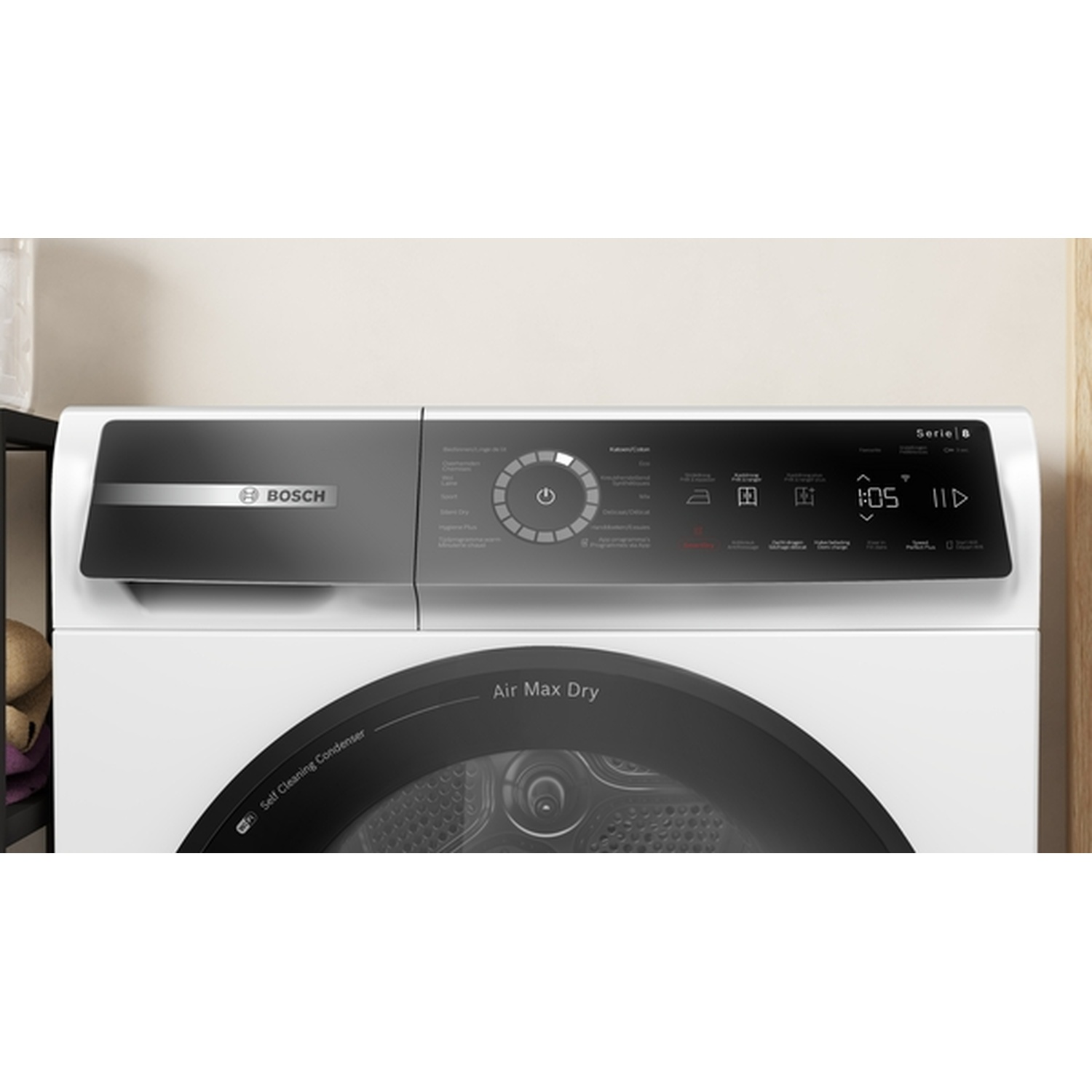 A close-up of a white Bosch dryer with a black door and control panel. It displays settings and a timer.