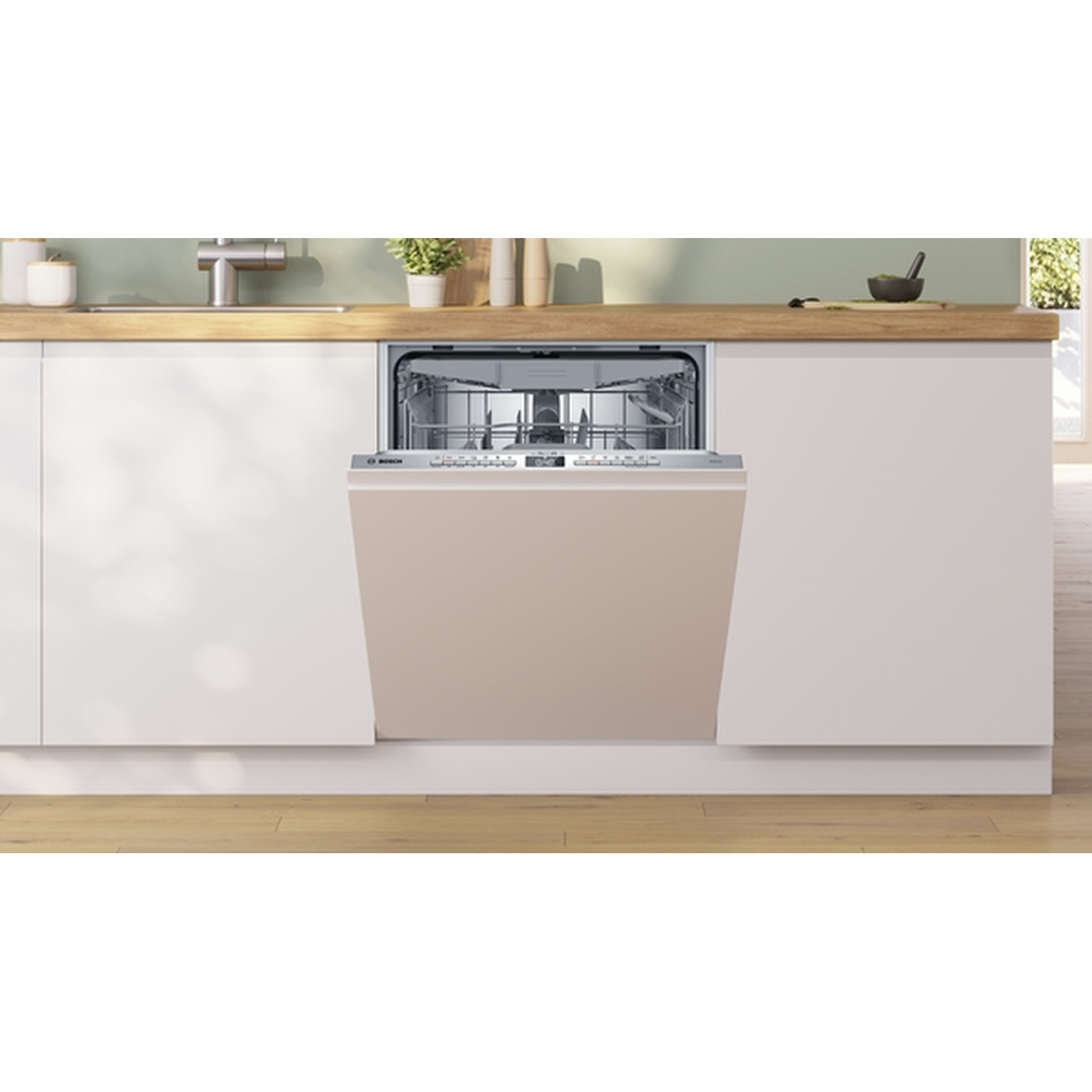 Open vaatwasser in een moderne keuken. Beige deur, roestvrijstalen interieur. Houten aanrecht, witte kasten. Groene muur.