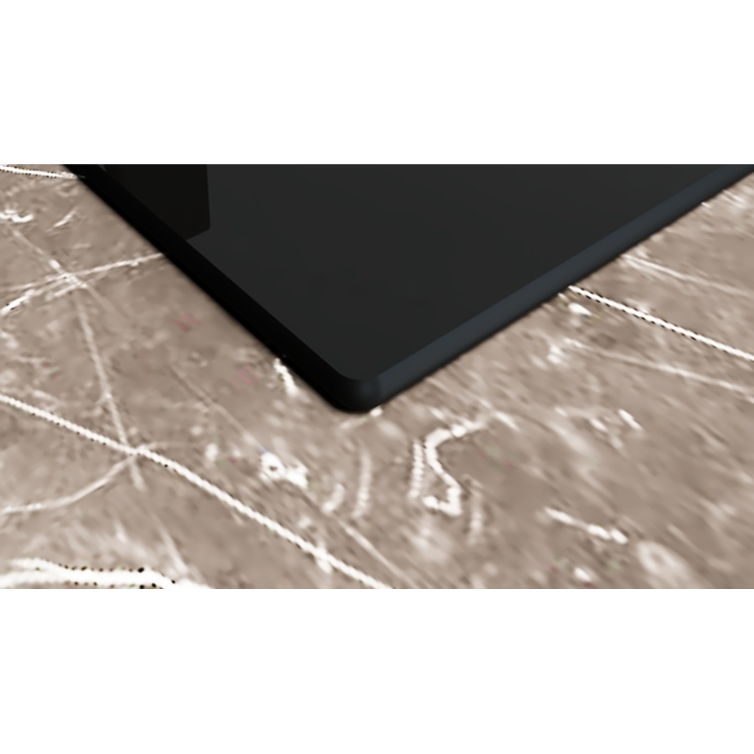Un objet rectangulaire noir sur une surface marbrée. Le coin de l'objet est visible. La surface présente des veines blanches.