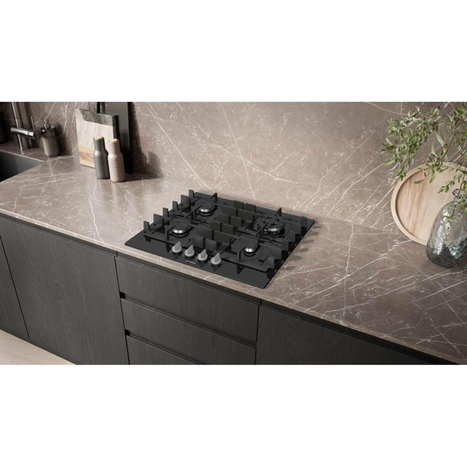 Une cuisine moderne avec une table de cuisson noire, des meubles sombres et un plan de travail en marbre. Accessoires: bouteilles, plateau.