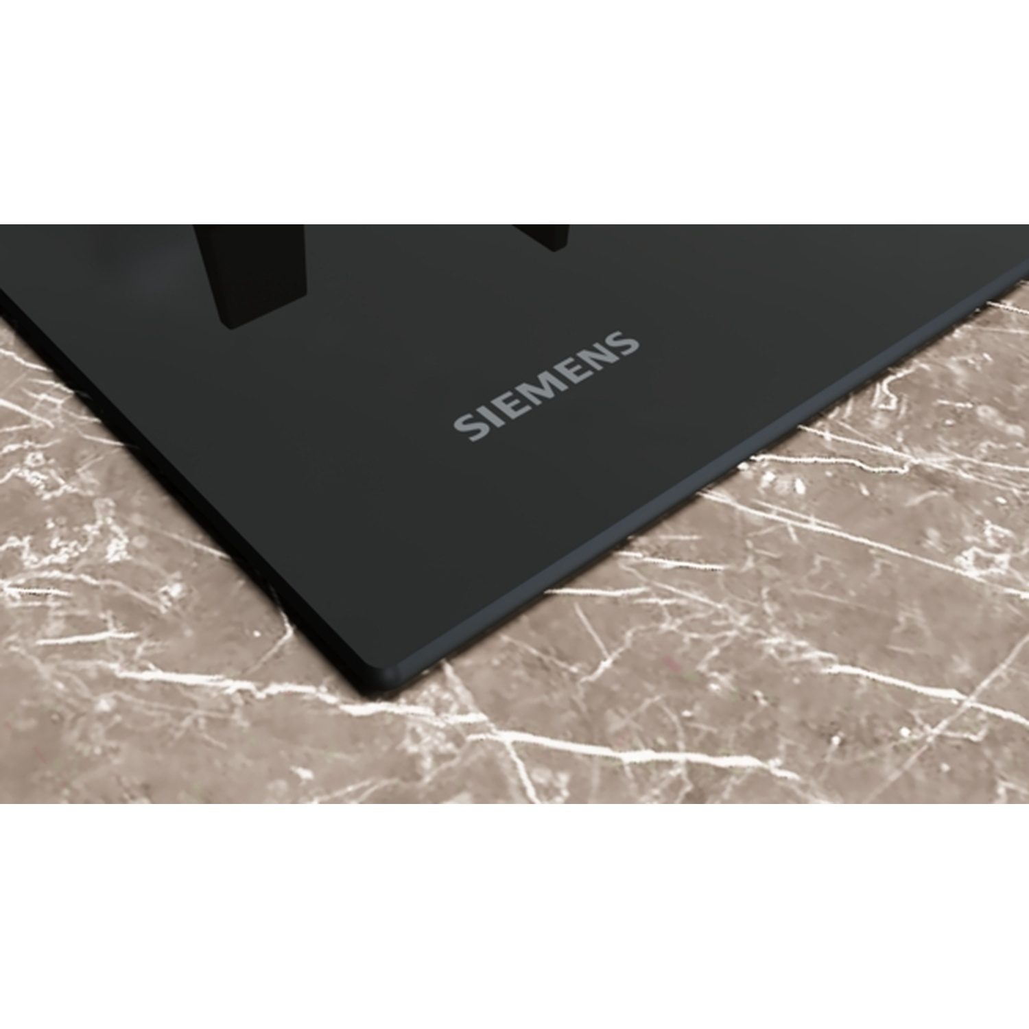 Une table de cuisson Siemens noire sur une surface à motifs de marbre. Le nom de la marque est visible.