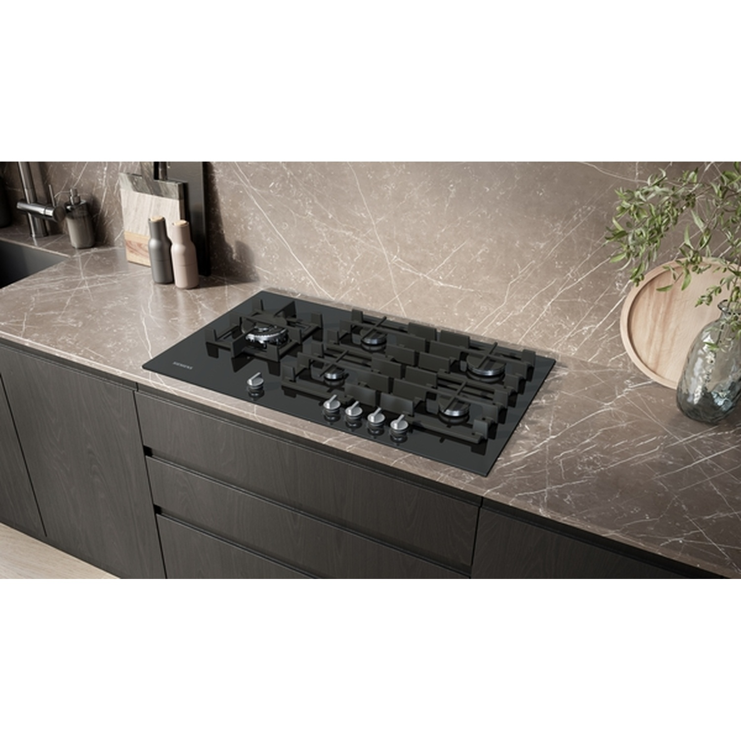 Une cuisine moderne avec une plaque de cuisson noire, des meubles sombres, un plan de travail en marbre et des objets décoratifs. La scène est bien éclairée.