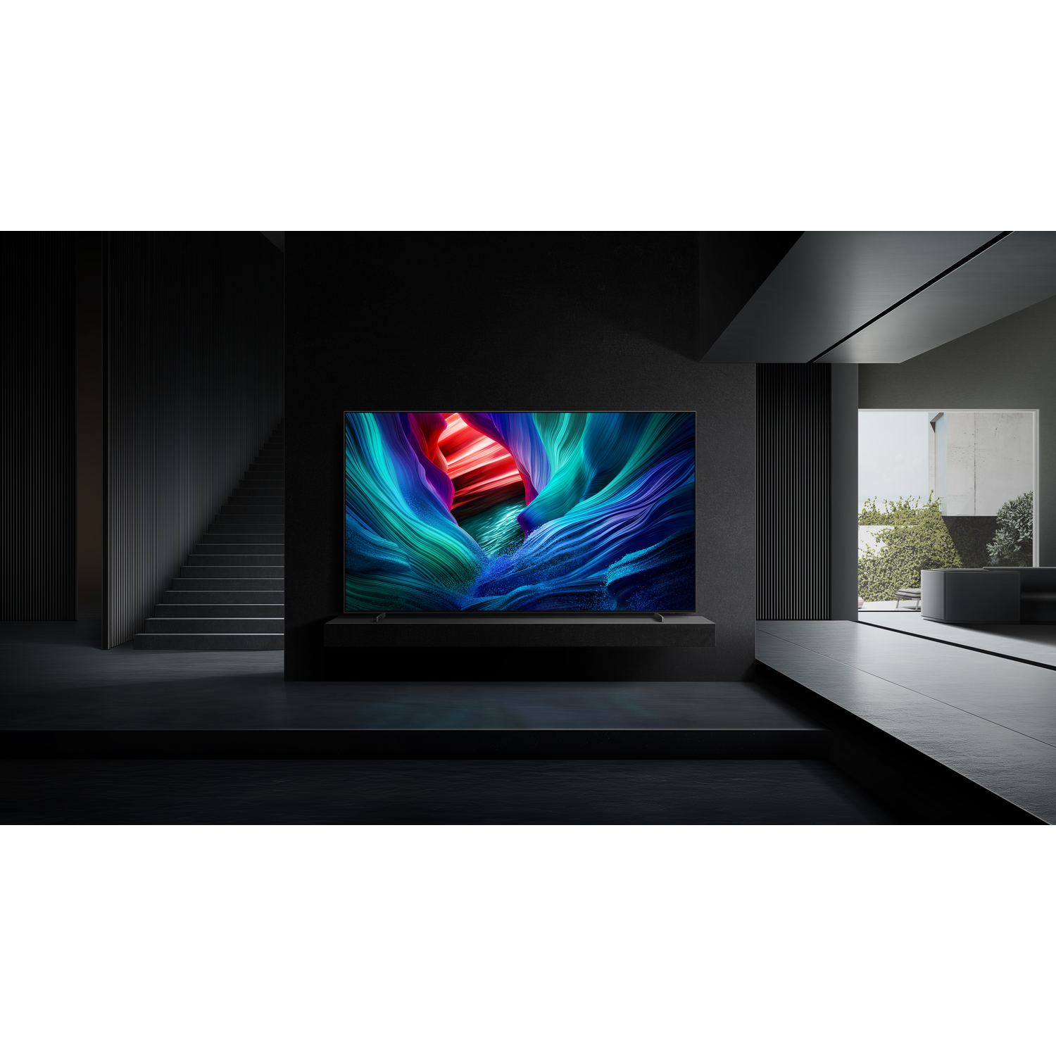 A large TV displays colorful abstract art. It's in a dark room with stairs, a window to greenery, and a minimalist design.