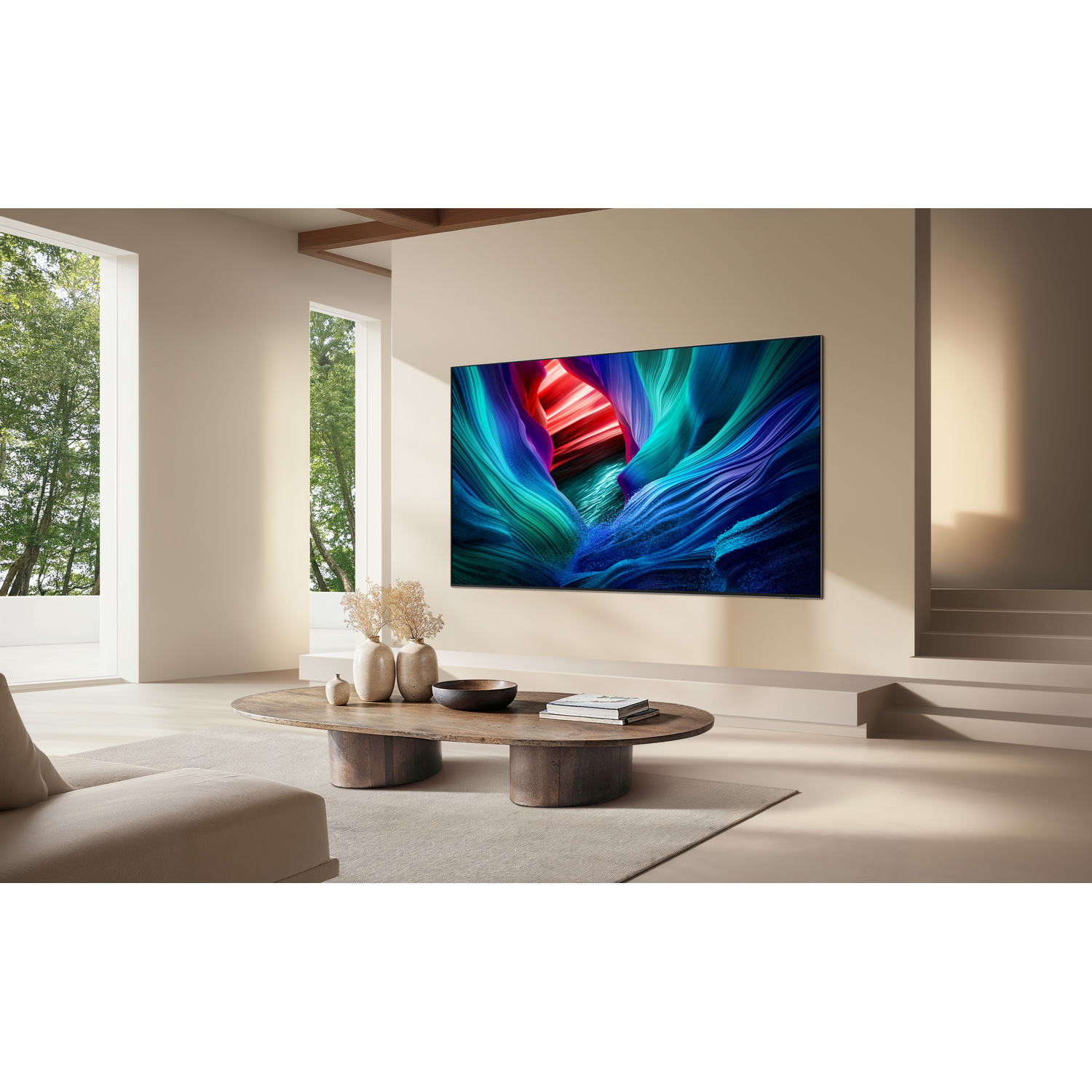 Living room with a large TV displaying colorful abstract art. A wooden coffee table with books and vases sits in front.