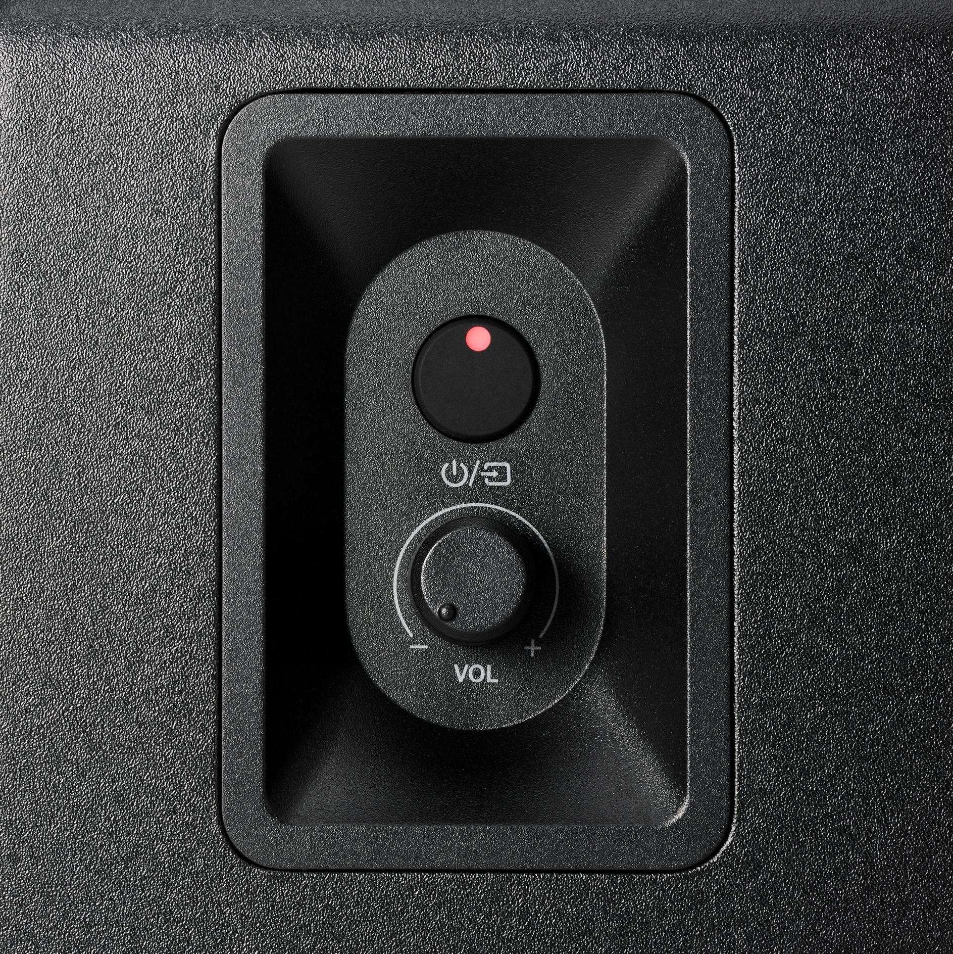 Primo piano del pannello di controllo di un altoparlante nero con luce rossa, pulsante di accensione e manopola del volume.