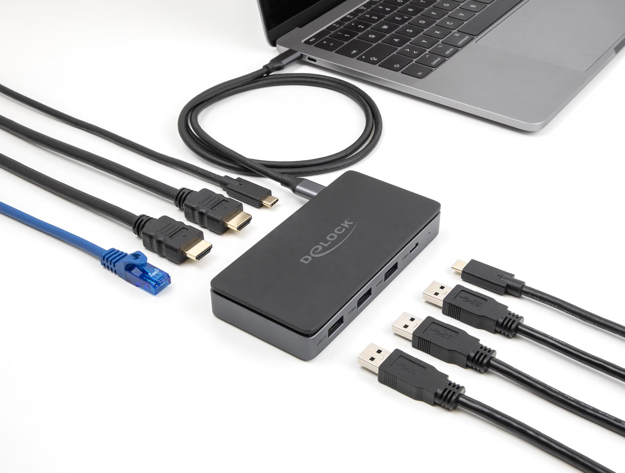 Ein Laptop mit einem schwarzen Hub und verschiedenen Kabeln: HDMI, USB und Ethernet auf einer weißen Oberfläche. Der Hub ist schwarz, mit der Marke 'D-Link'.